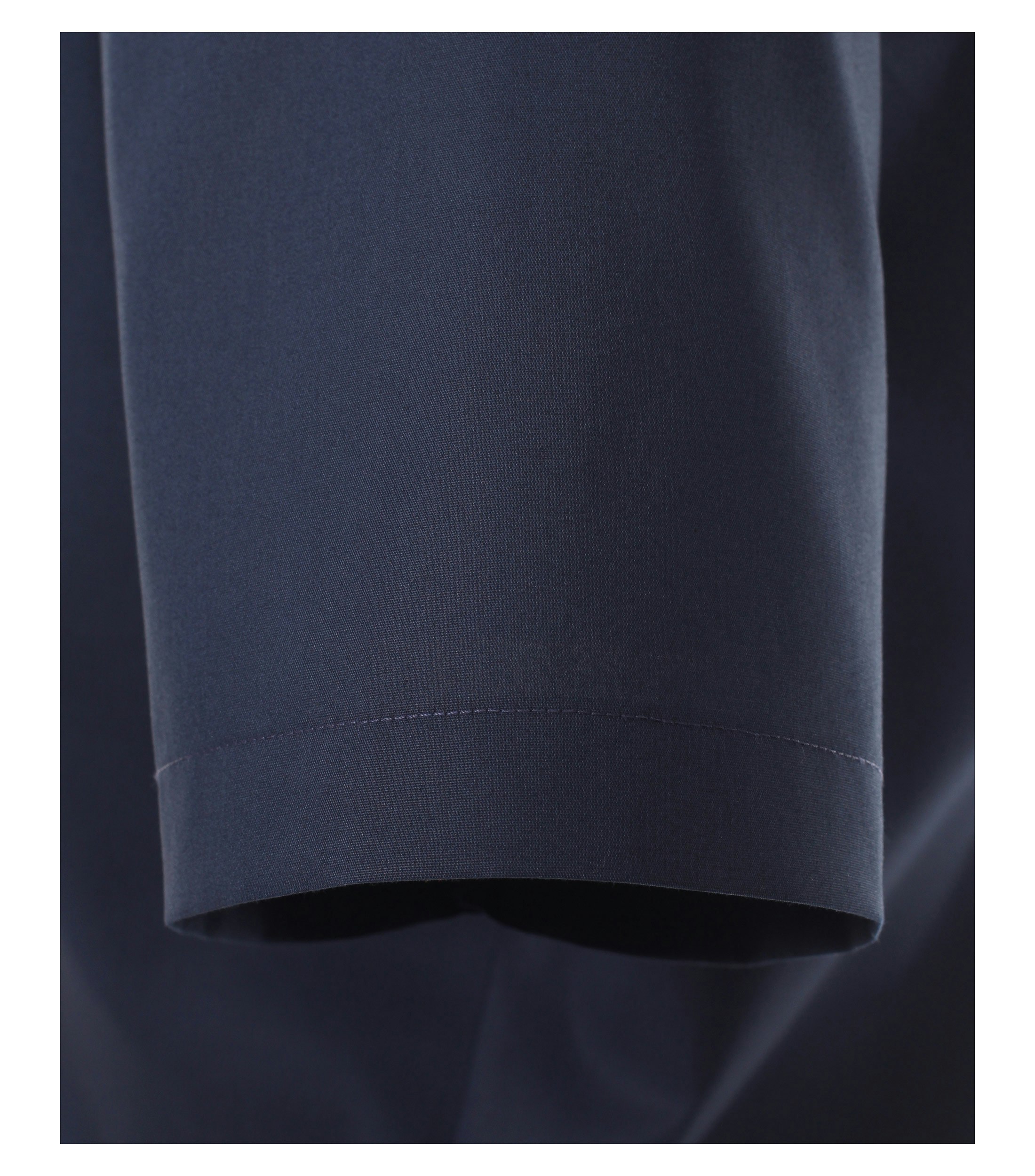 Das Model trägt ein Businesshemd im uni Muster in der Farbe Dunkelblau