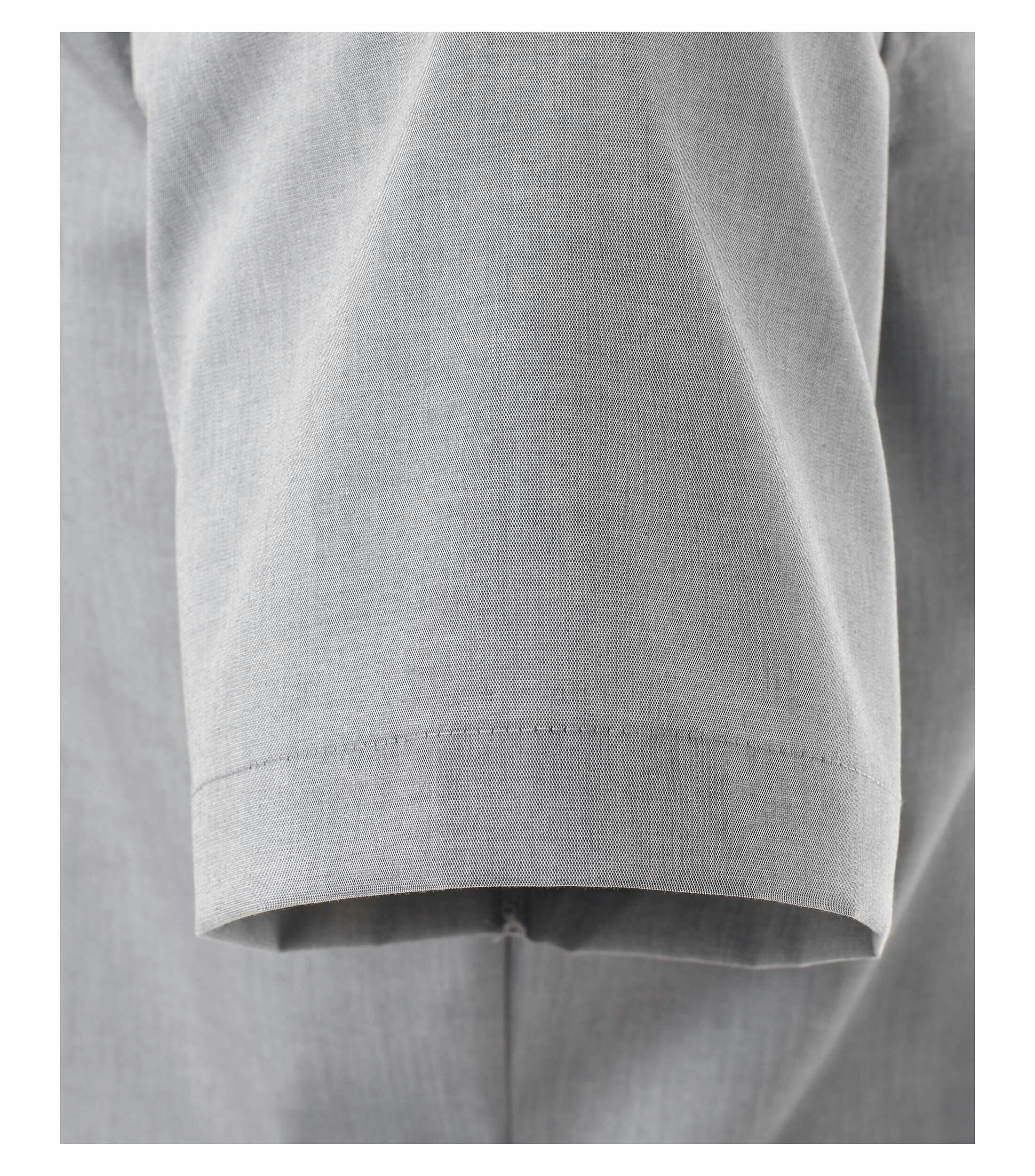 Das Model trägt ein Businesshemd im uni Muster in der Farbe Hellgrau