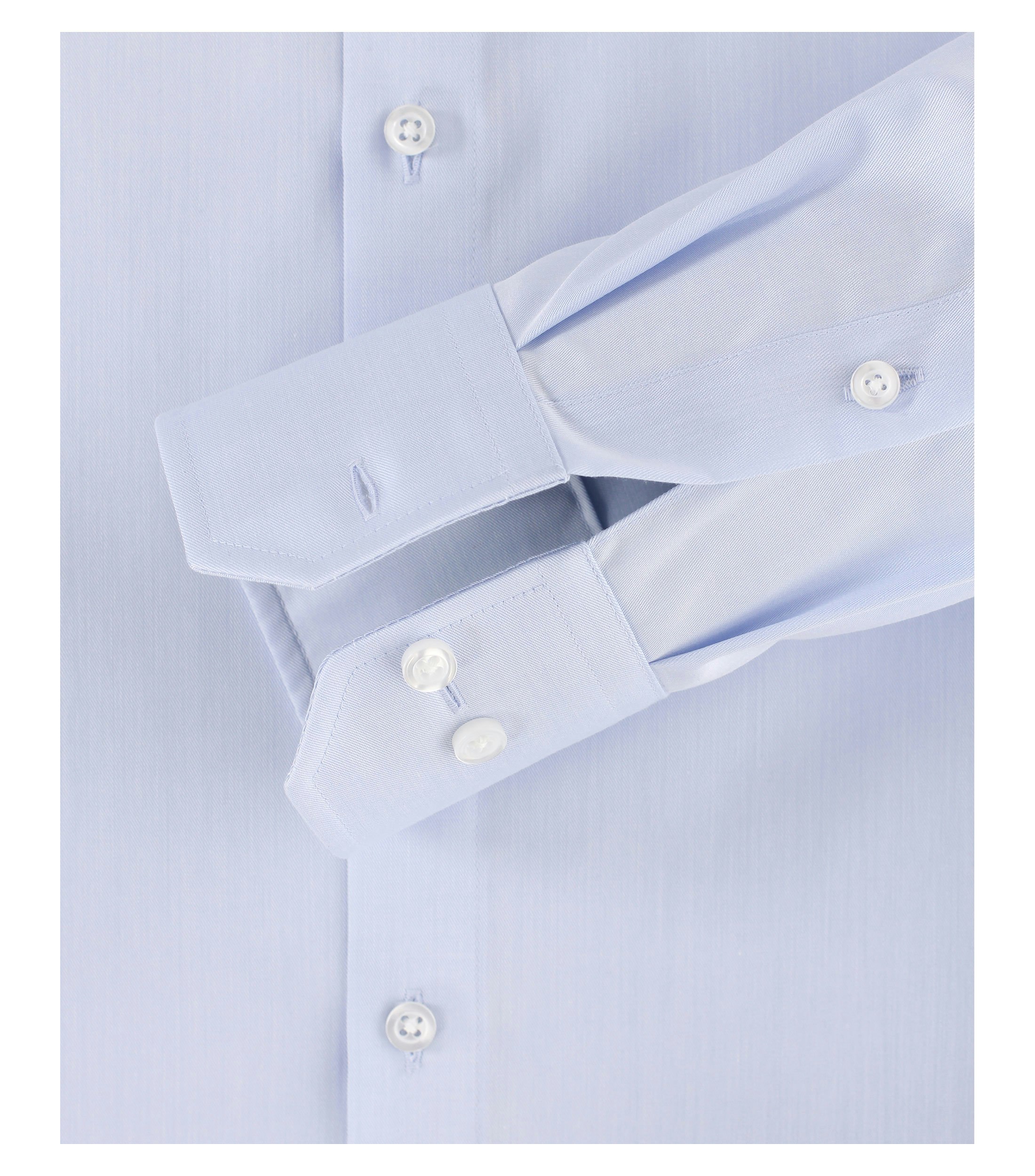 Das Model trägt ein Businesshemd im uni Muster in der Farbe Hellblau