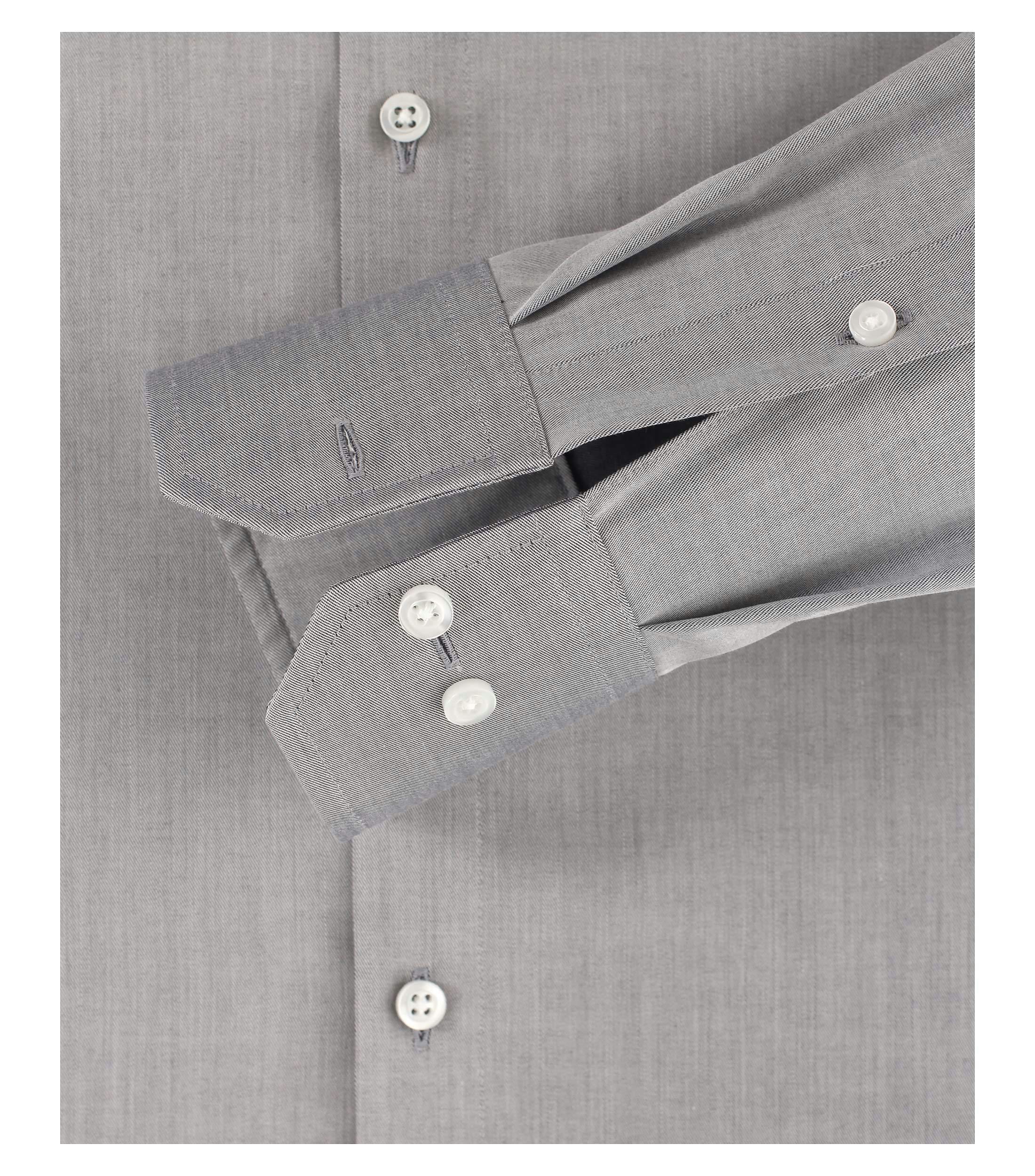 Das Model trägt ein Businesshemd im uni Muster in der Farbe Hellgrau