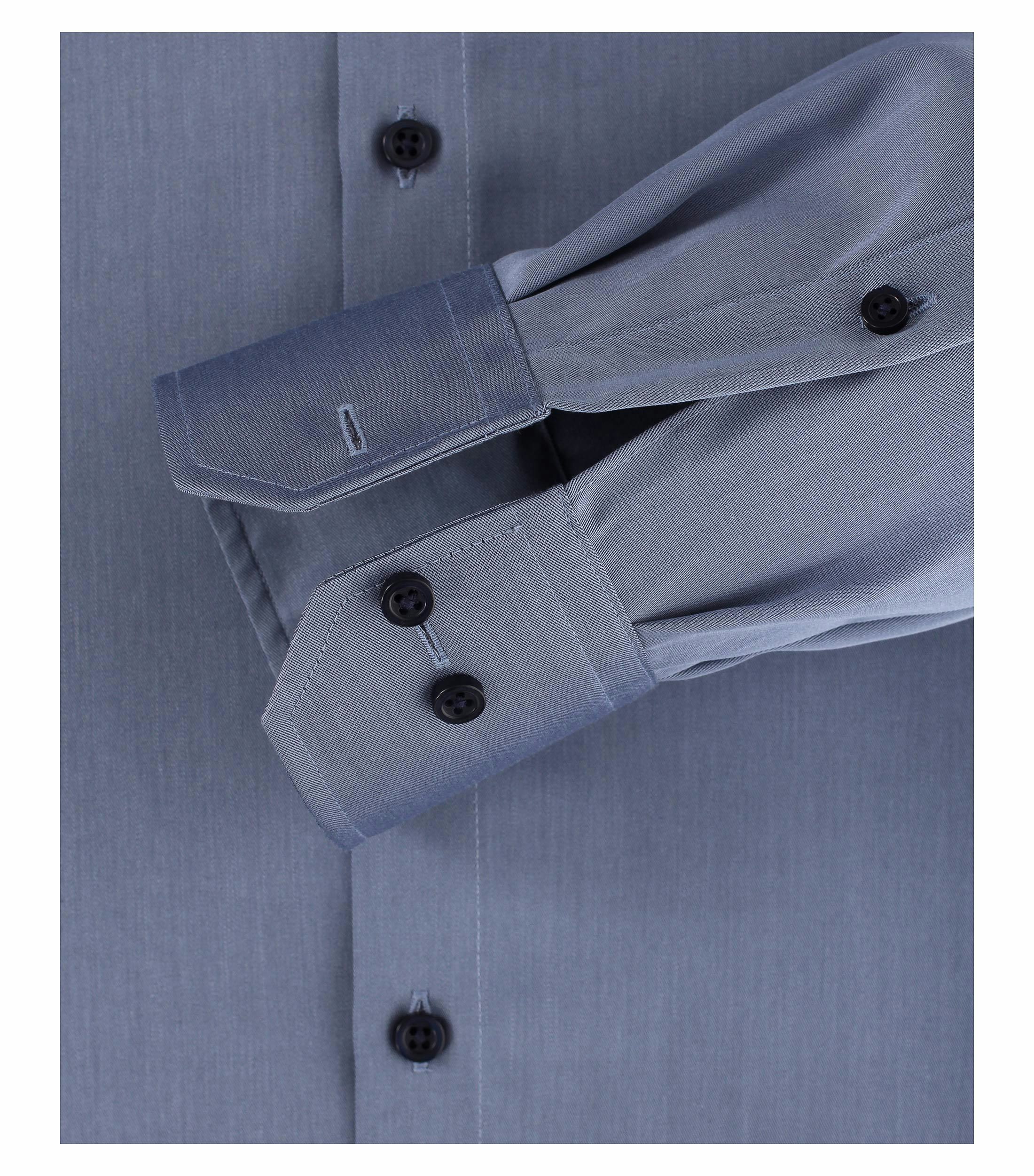 Das Model trägt ein Businesshemd im uni Muster in der Farbe sattes Dunkelblau