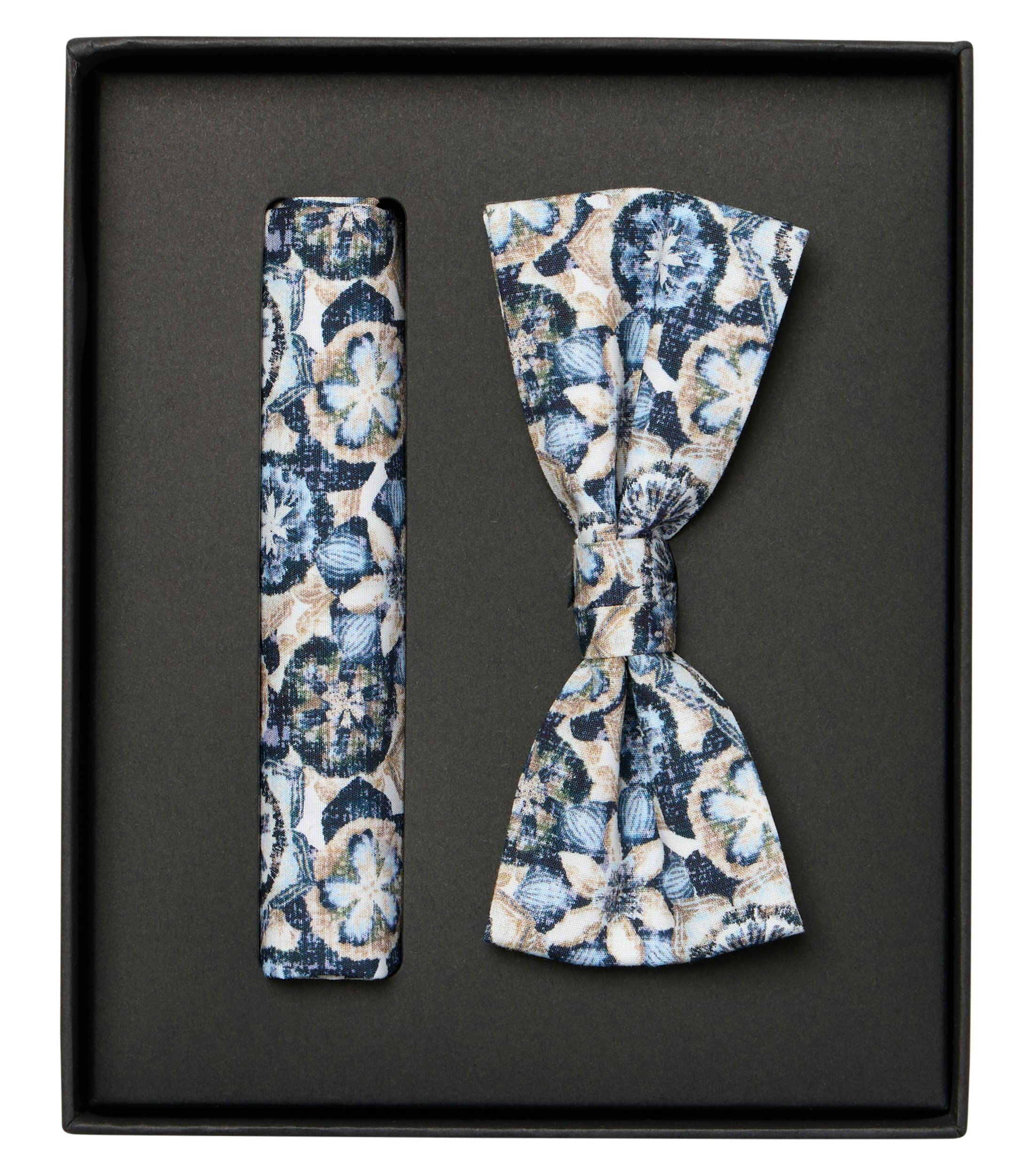 Das Model trägt eine Fliege und Einstecktuch im gemustert Muster in der Farbe Blau