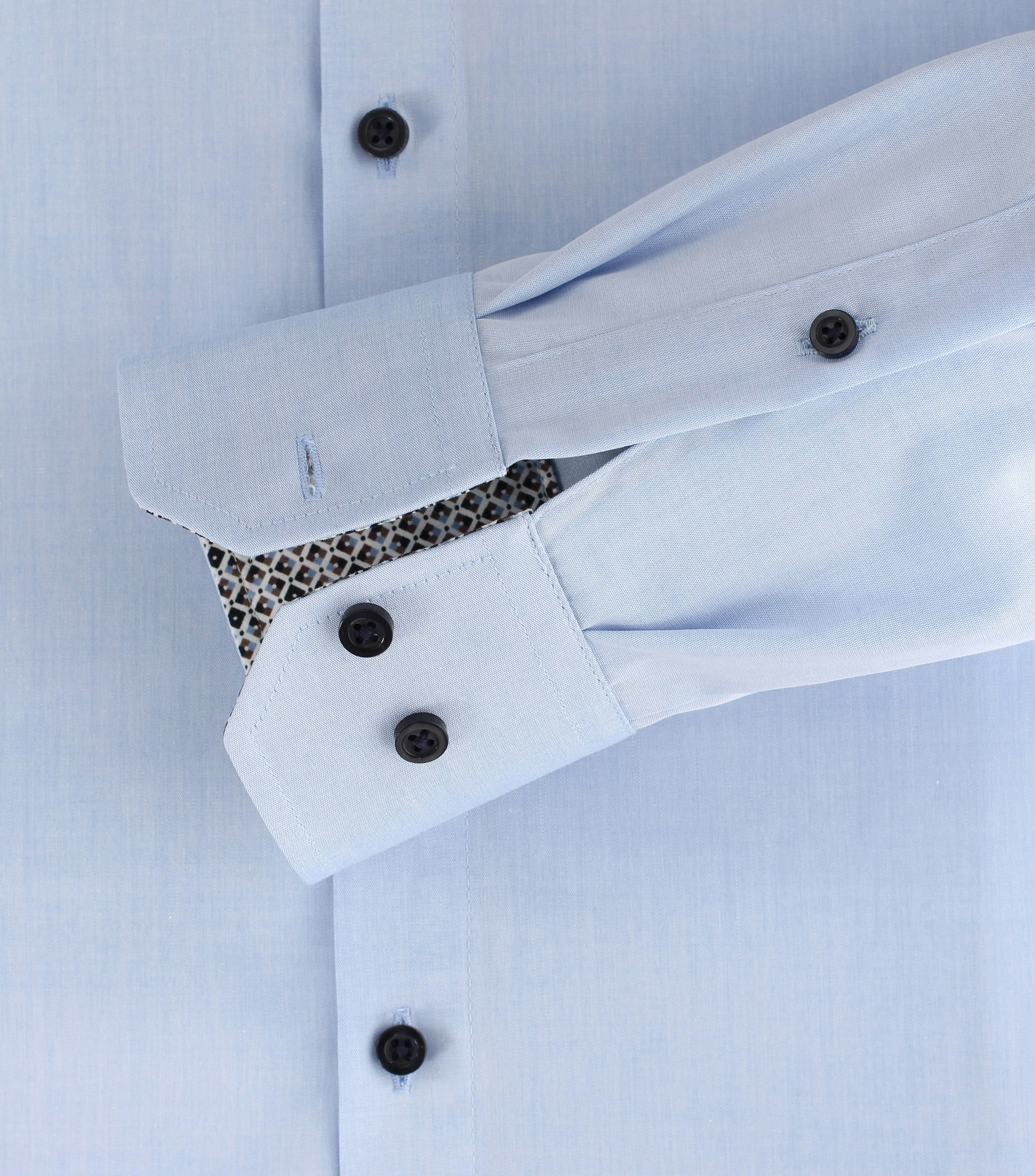 Das Model trägt ein Businesshemd im uni Muster in der Farbe Hellblau