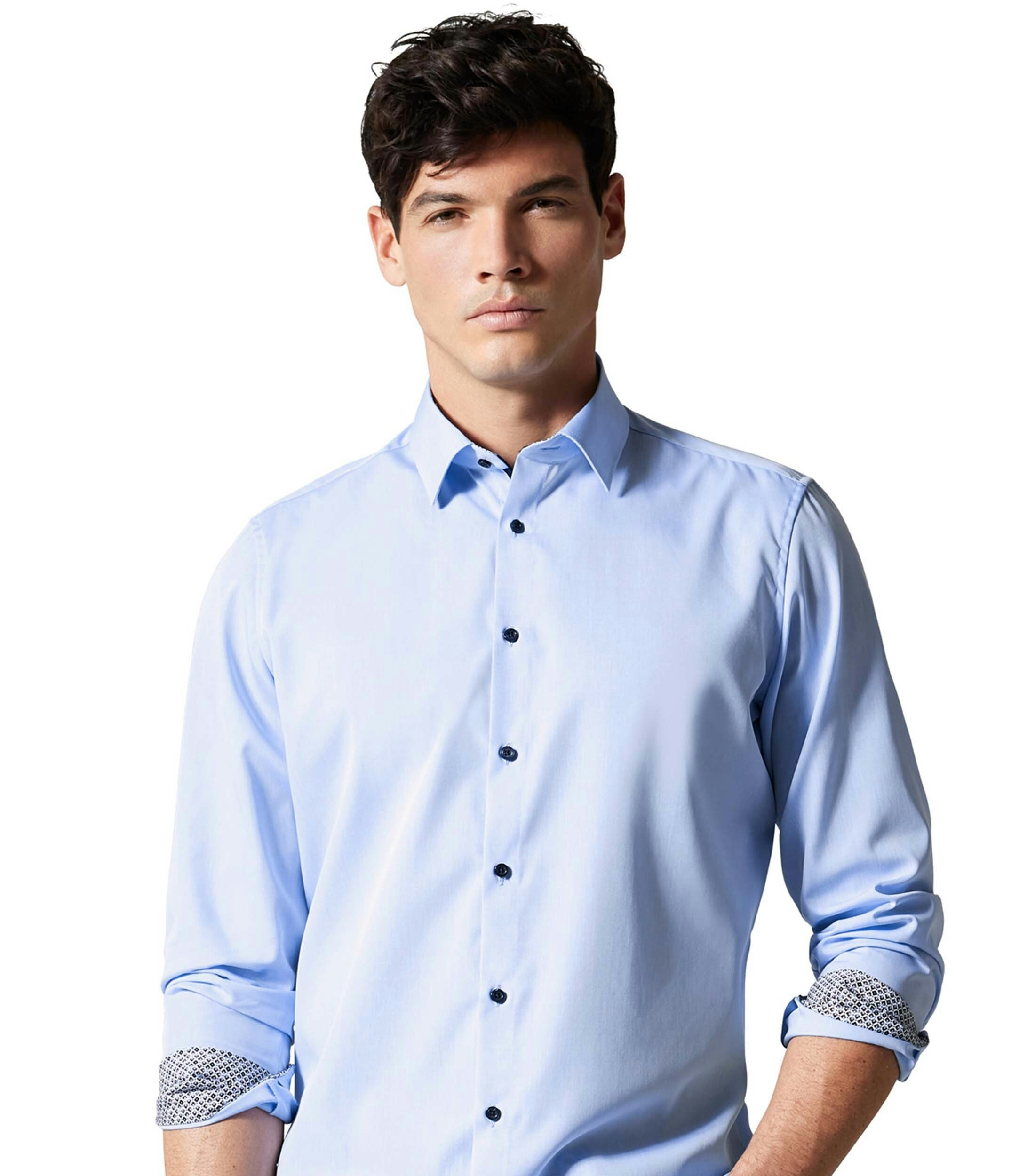 Das Model trägt ein Businesshemd im uni Muster in der Farbe Hellblau