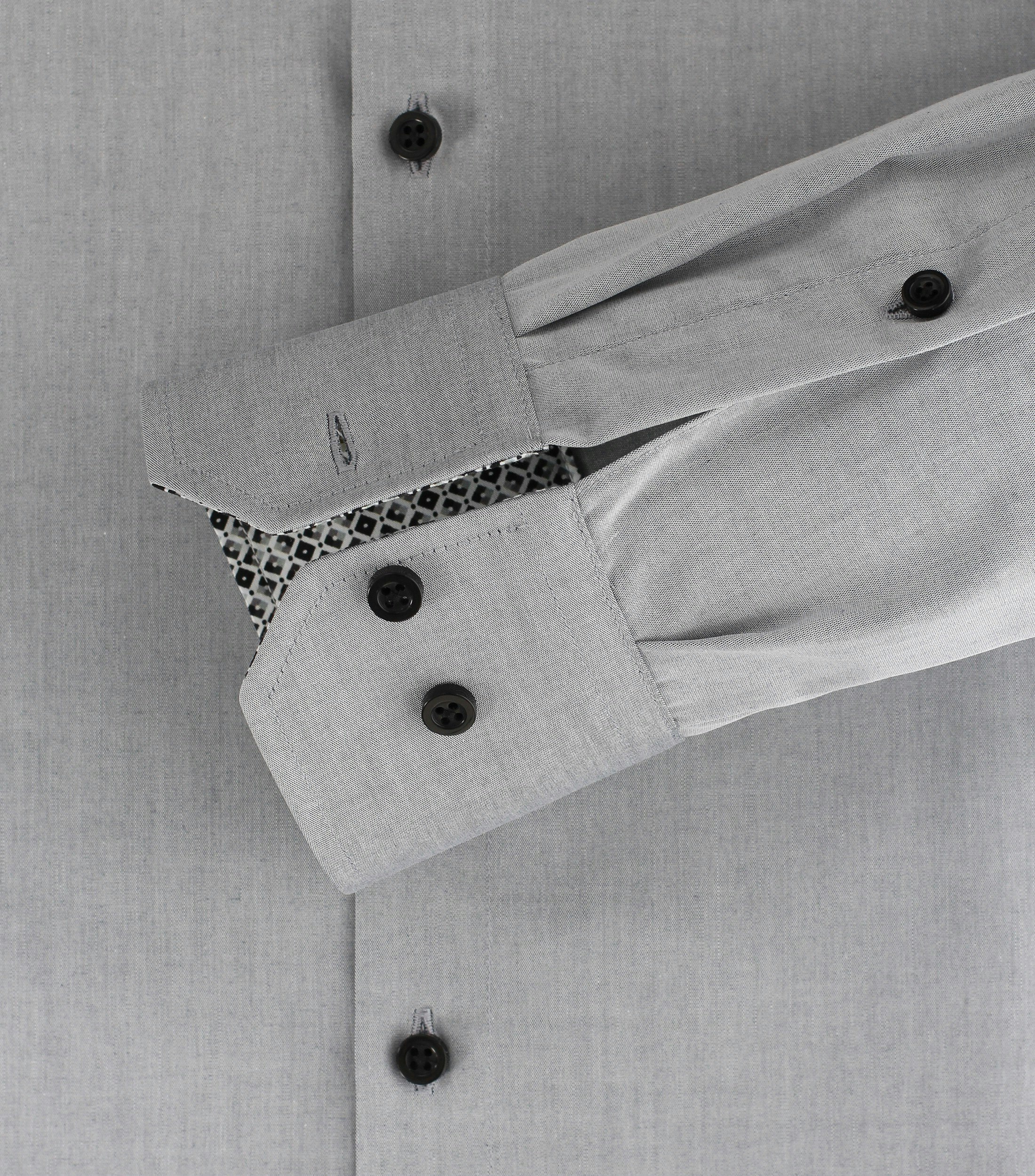 Das Model trägt ein Businesshemd im uni Muster in der Farbe Hellgrau