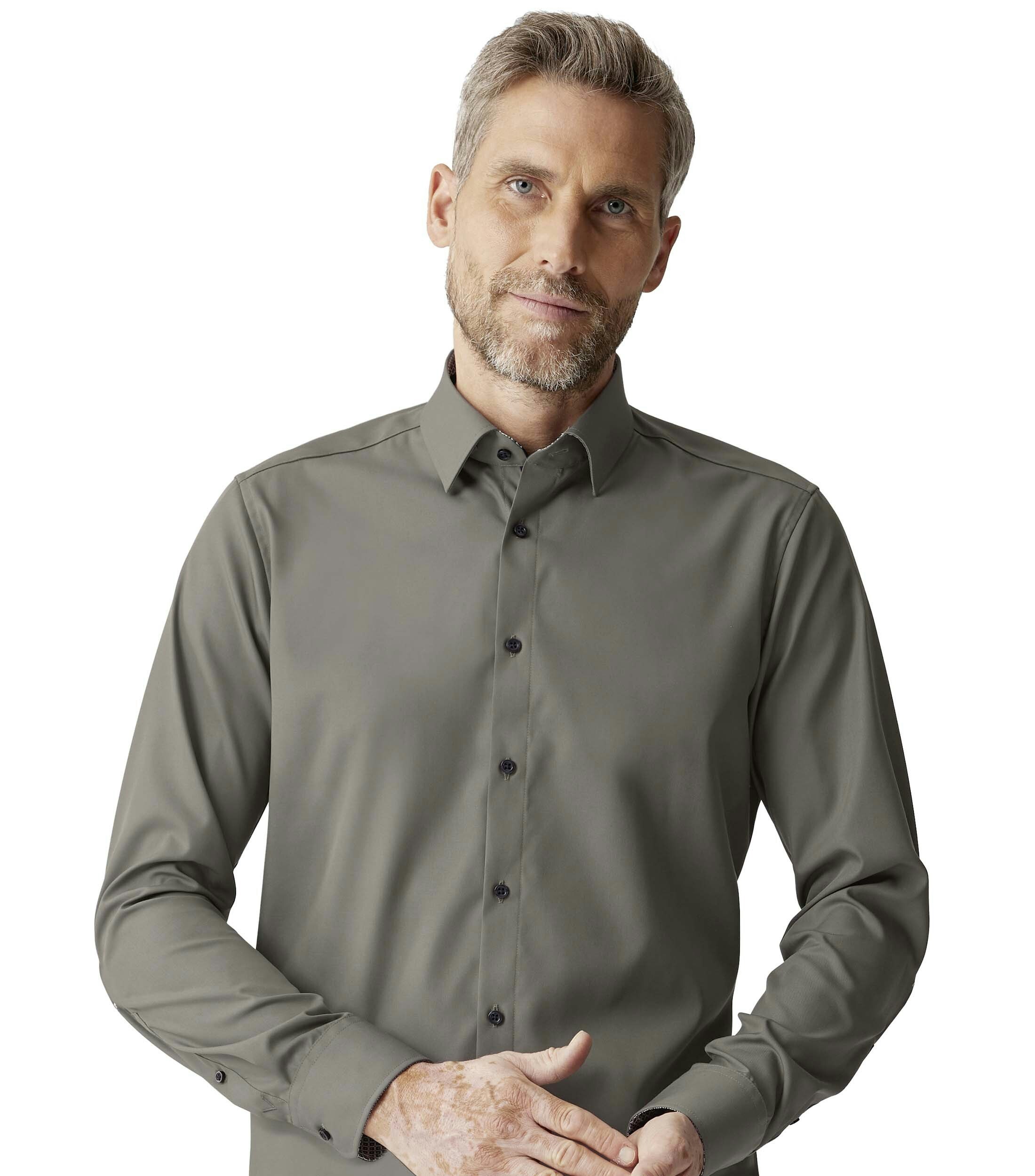 Das Model trägt ein Businesshemd im uni Muster in der Farbe Olive