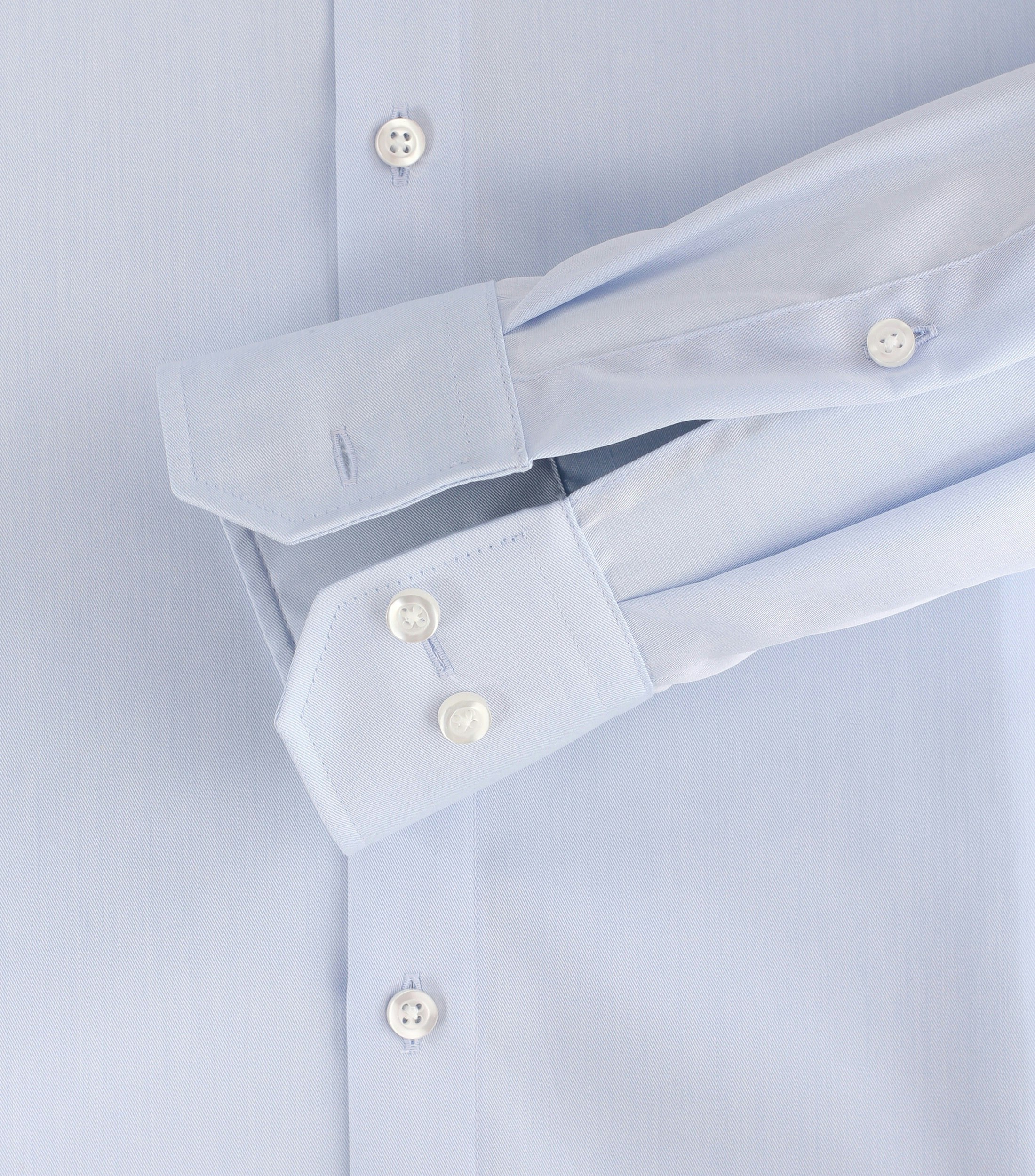 Das Model trägt ein Businesshemd im uni Muster in der Farbe Hellblau