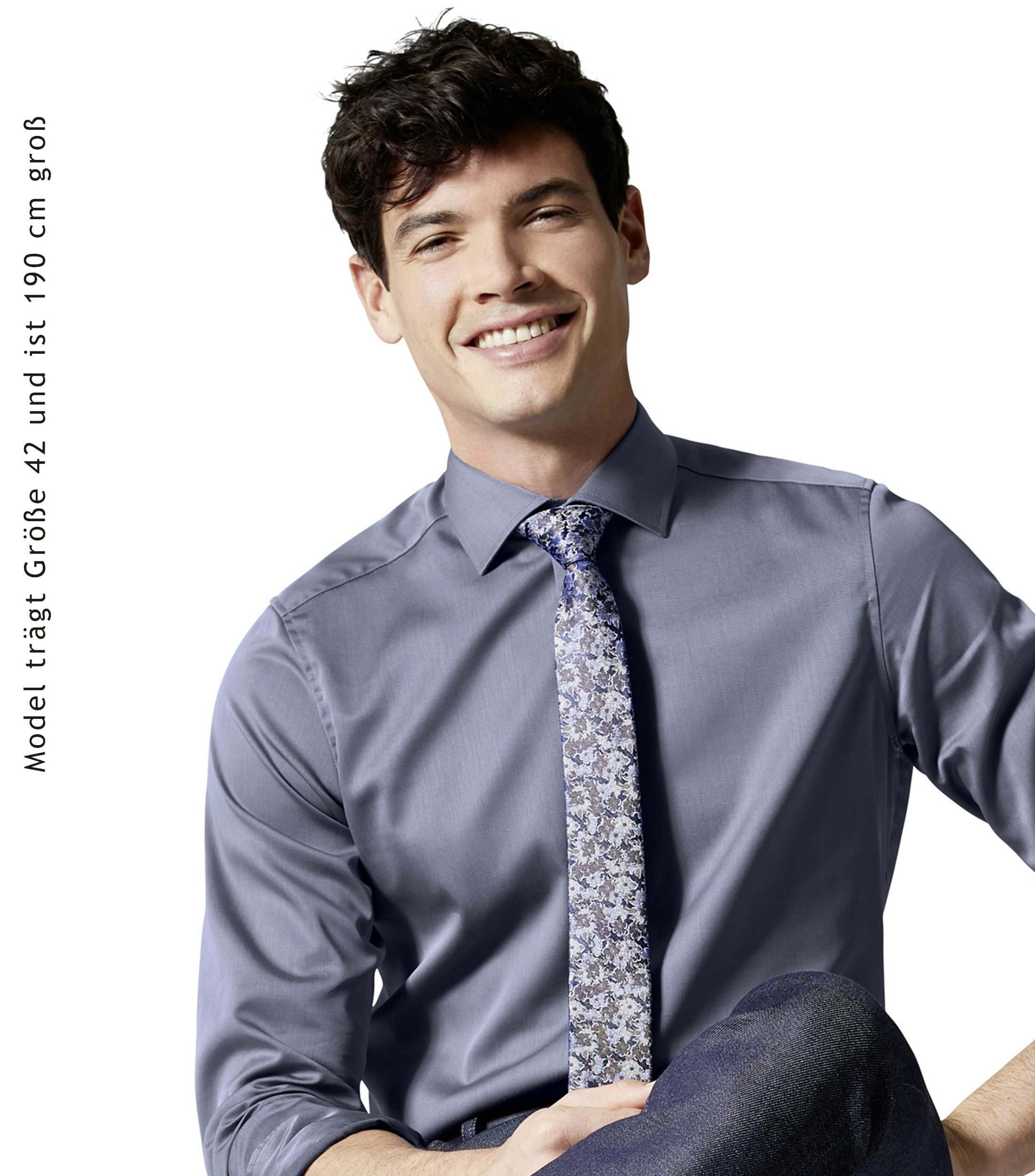 Das Model trägt ein Businesshemd im uni Muster in der Farbe Mittelblau