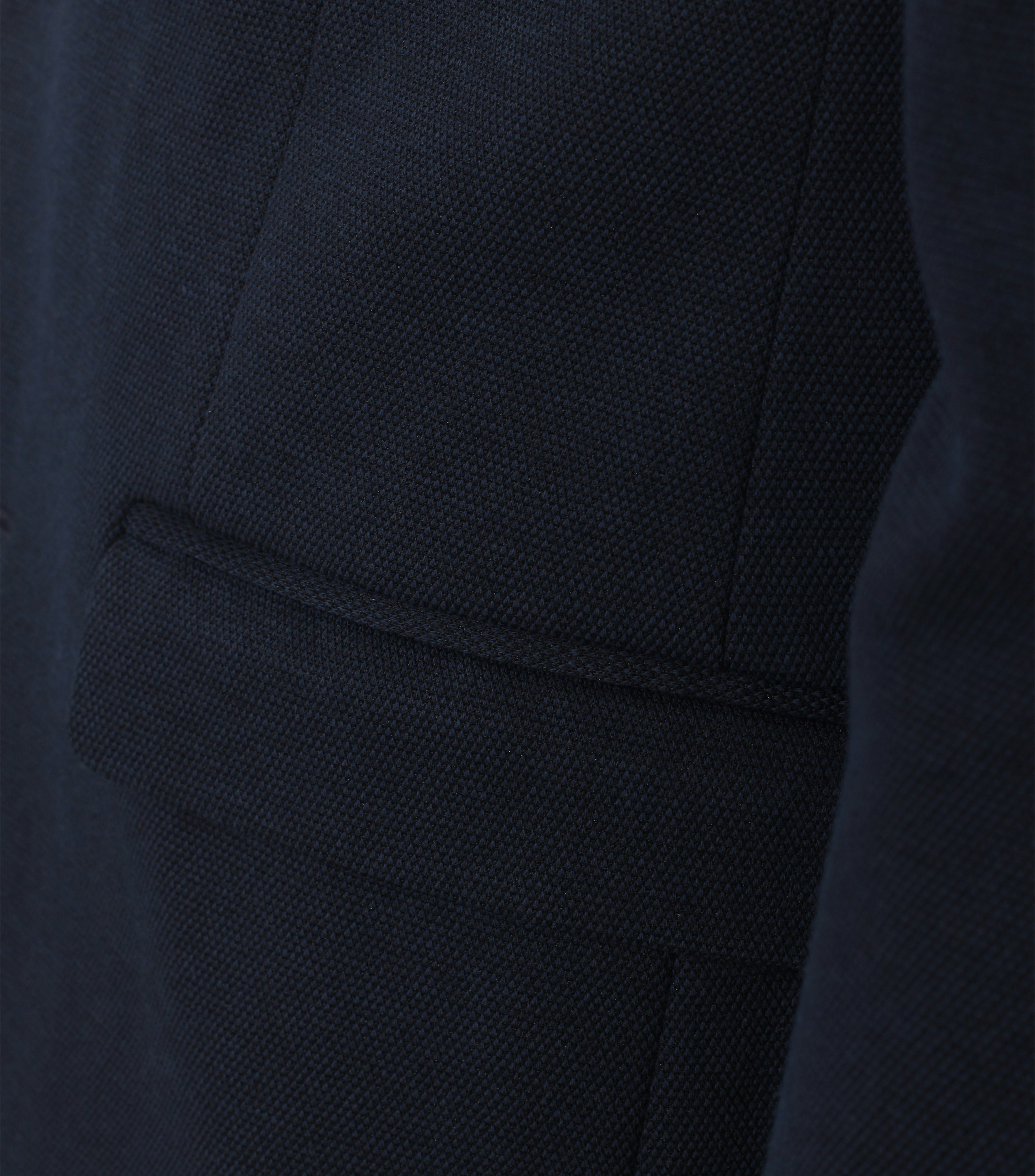 Das Model trägt ein Sakko im uni Muster in der Farbe Dunkelblau