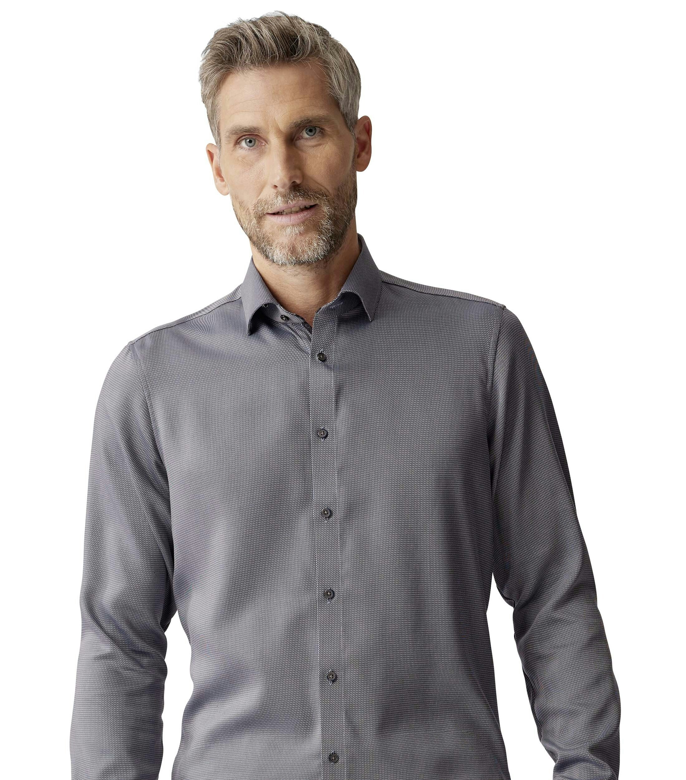 Das Model trägt ein Businesshemd im uni Muster in der Farbe Braun