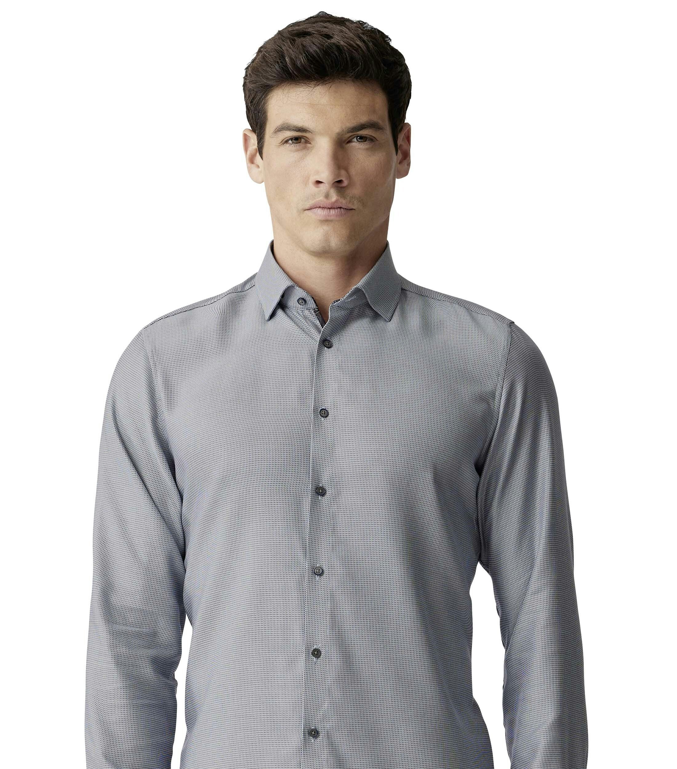 Das Model trägt ein Businesshemd im uni Muster in der Farbe Hellbraun