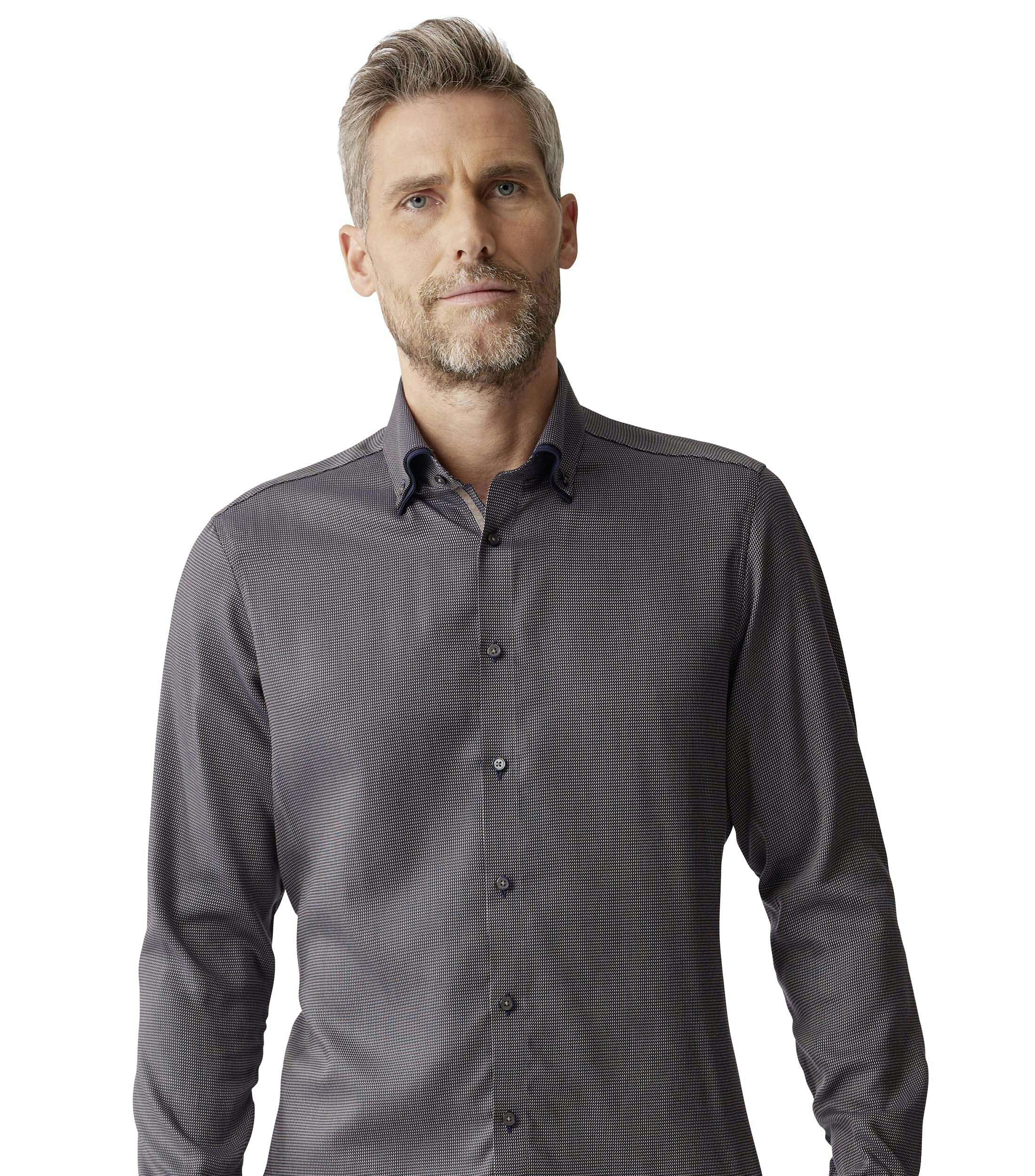 Das Model trägt ein Businesshemd im uni Muster in der Farbe Braun