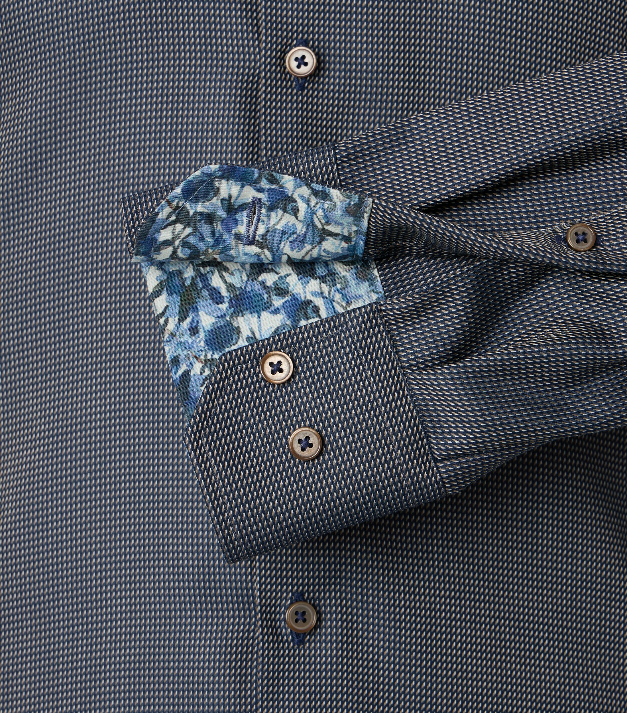 Das Model trägt ein Businesshemd im uni Muster in der Farbe Dunkelblau