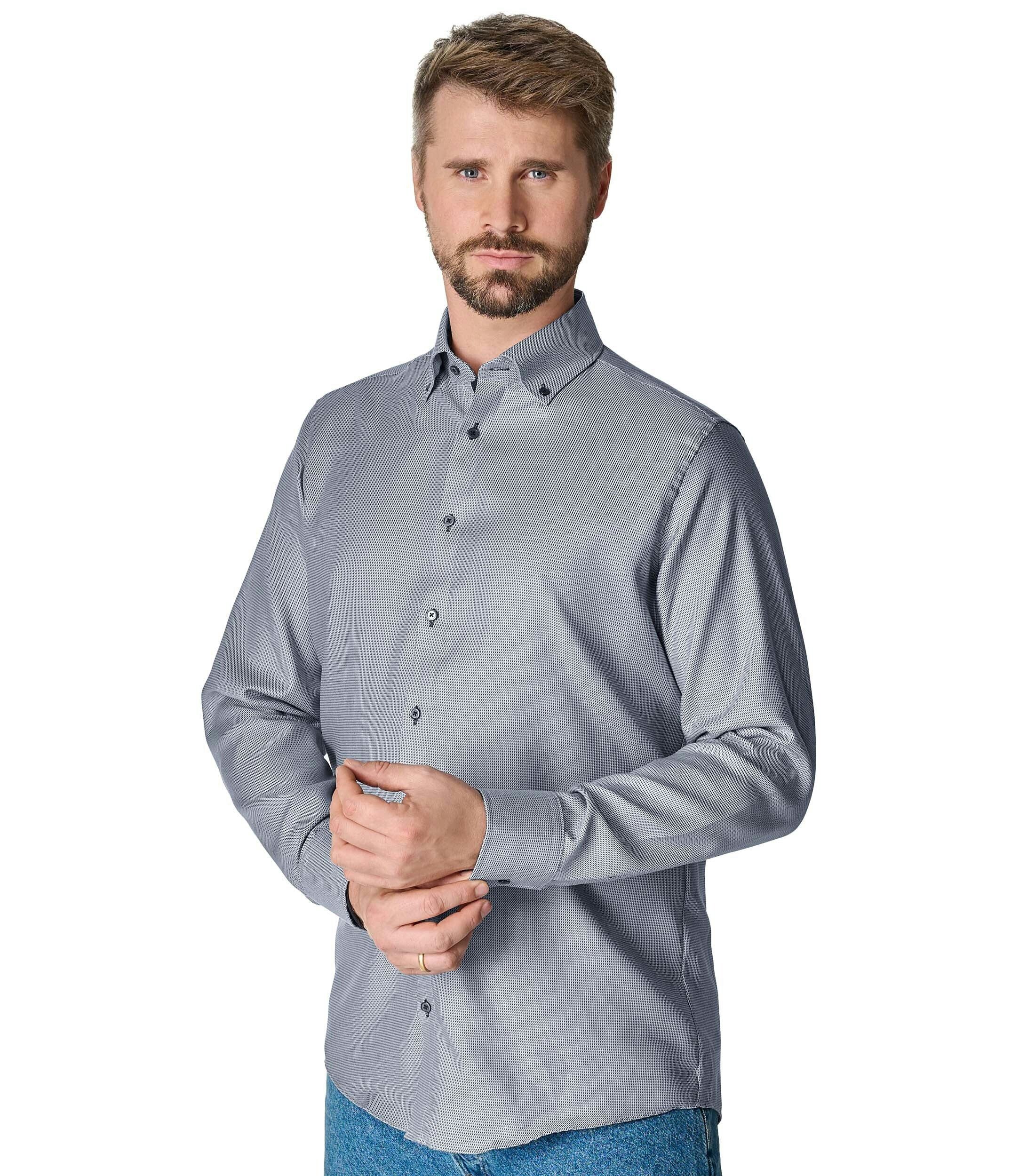 Das Model trägt ein Businesshemd im uni Muster in der Farbe Hellblau