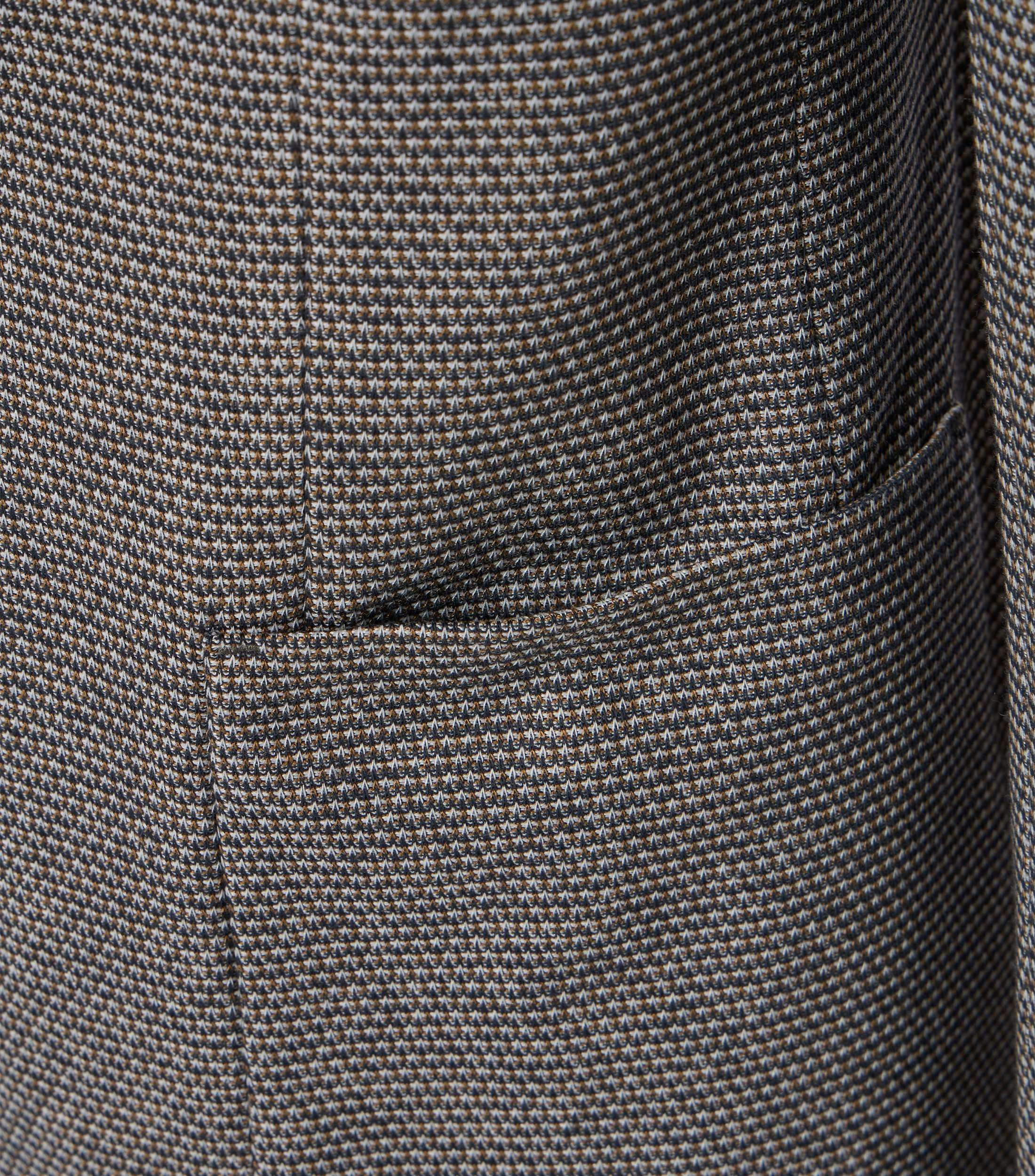 Das Model trägt ein Sakko im uni Muster in der Farbe Beige