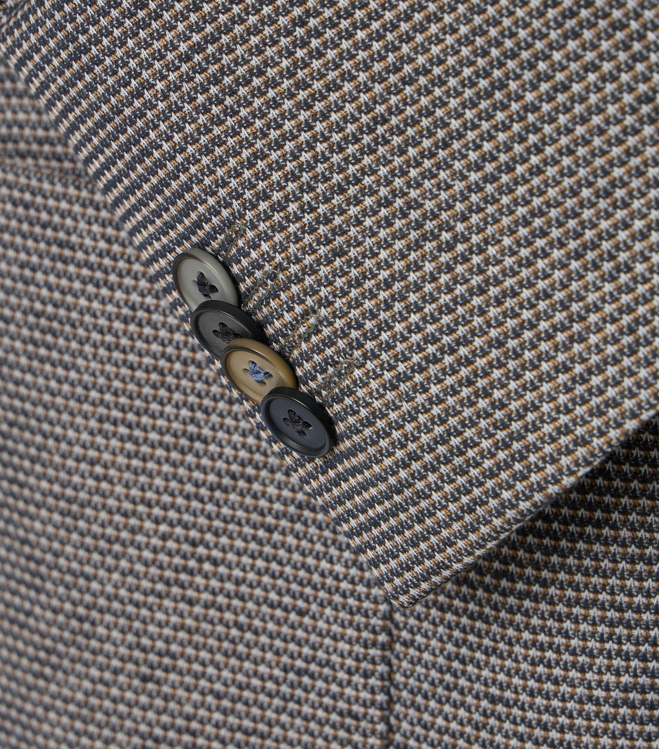 Das Model trägt ein Sakko im uni Muster in der Farbe Beige