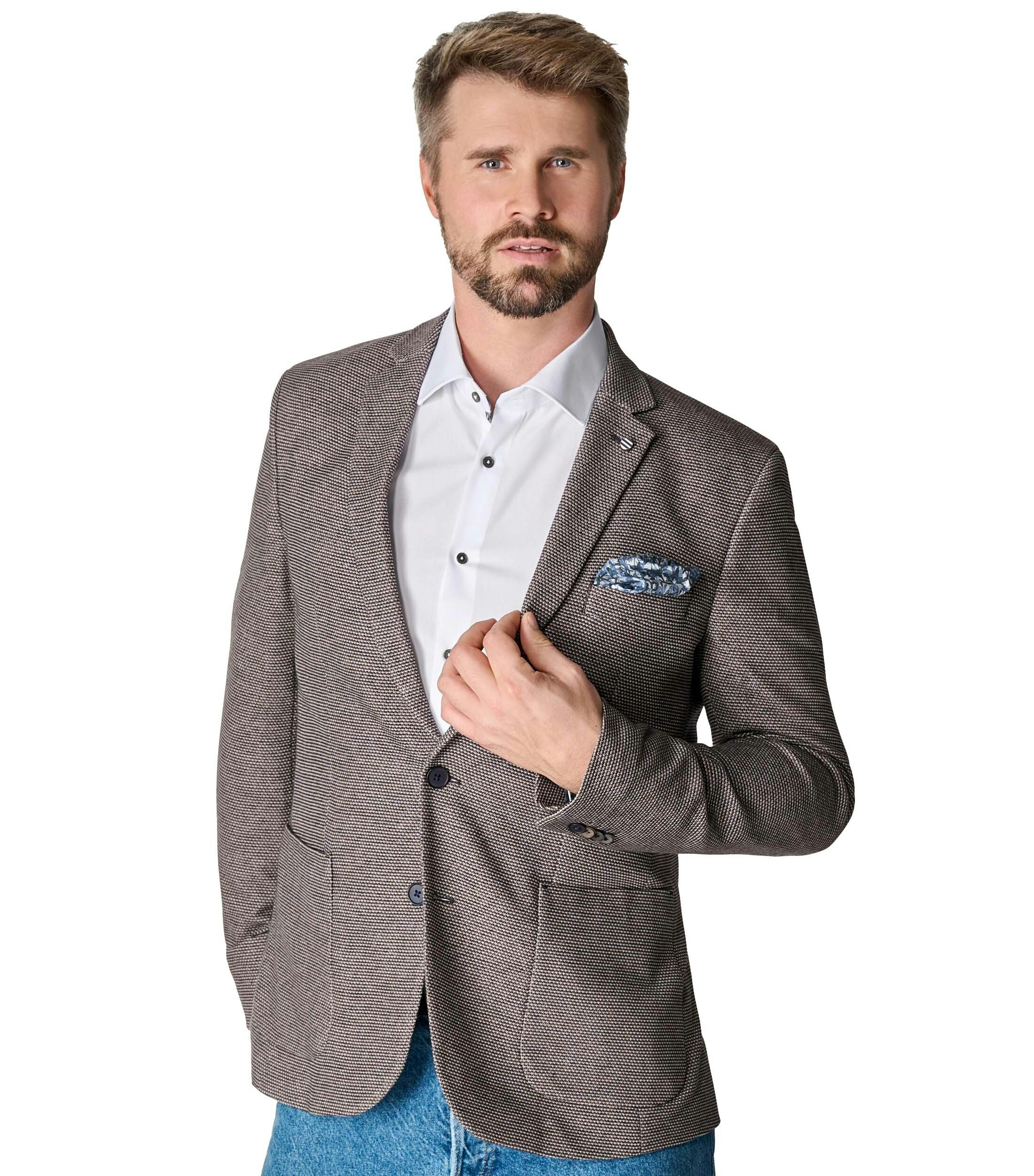 Das Model trägt ein Sakko im uni Muster in der Farbe Beige