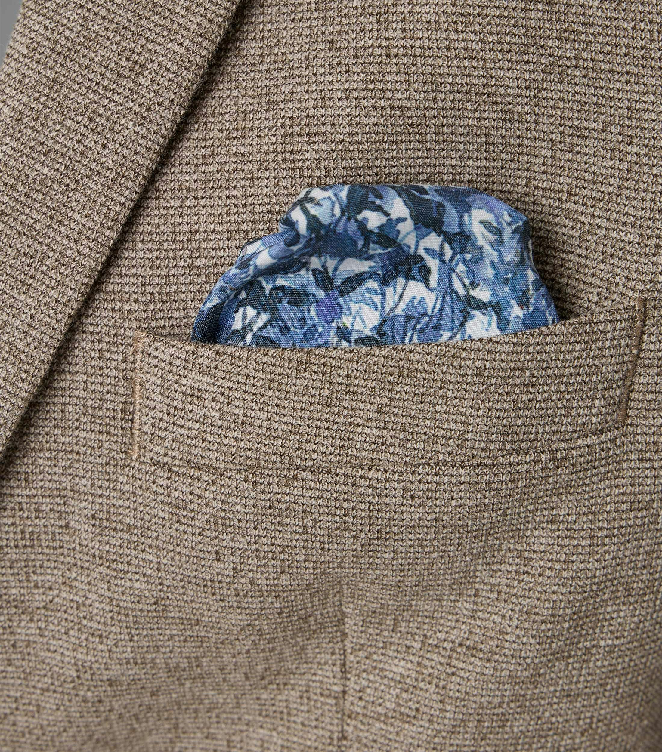 Das Model trägt ein Sakko im uni Muster in der Farbe Beige