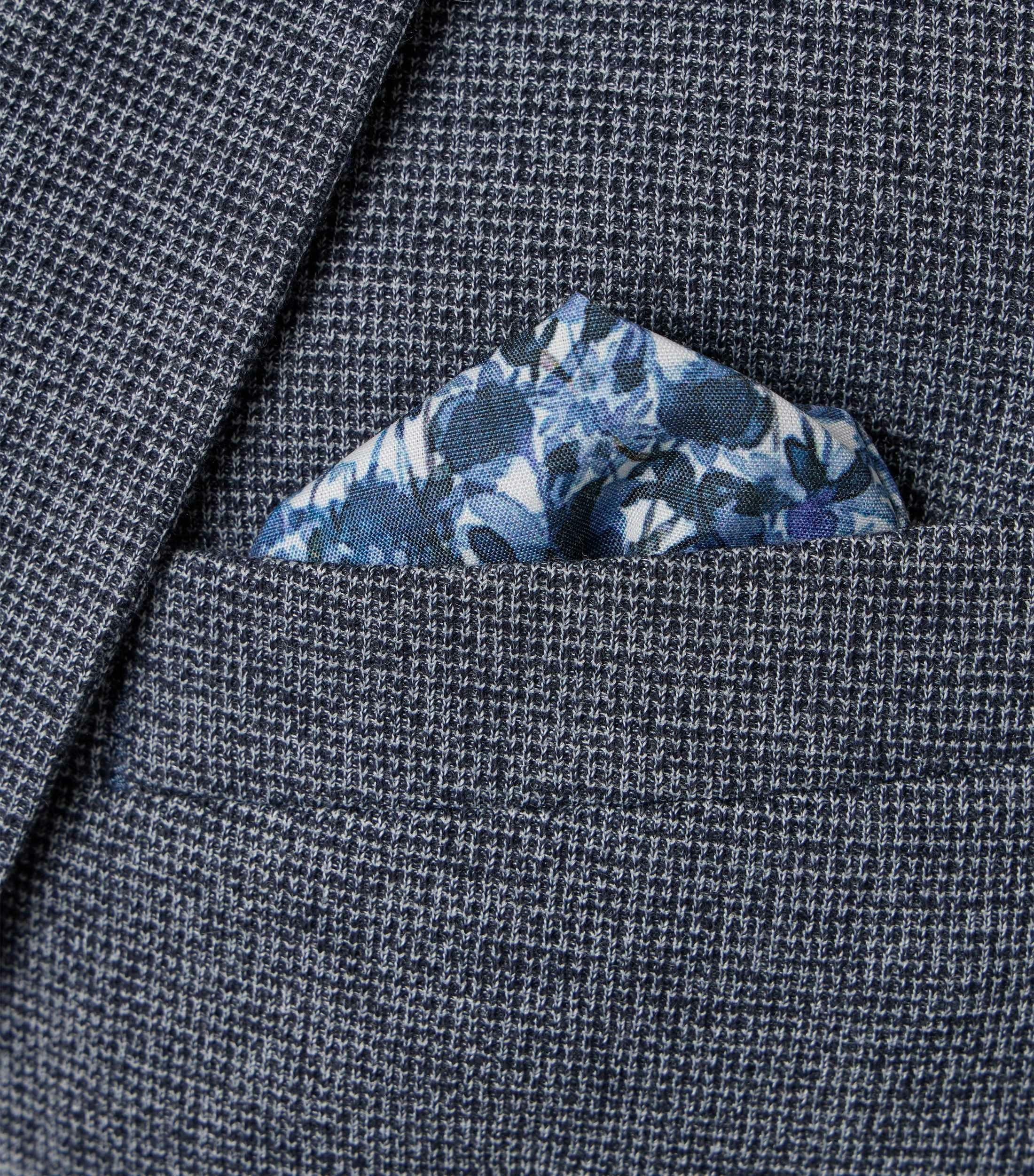 Das Model trägt ein Sakko im uni Muster in der Farbe Grau