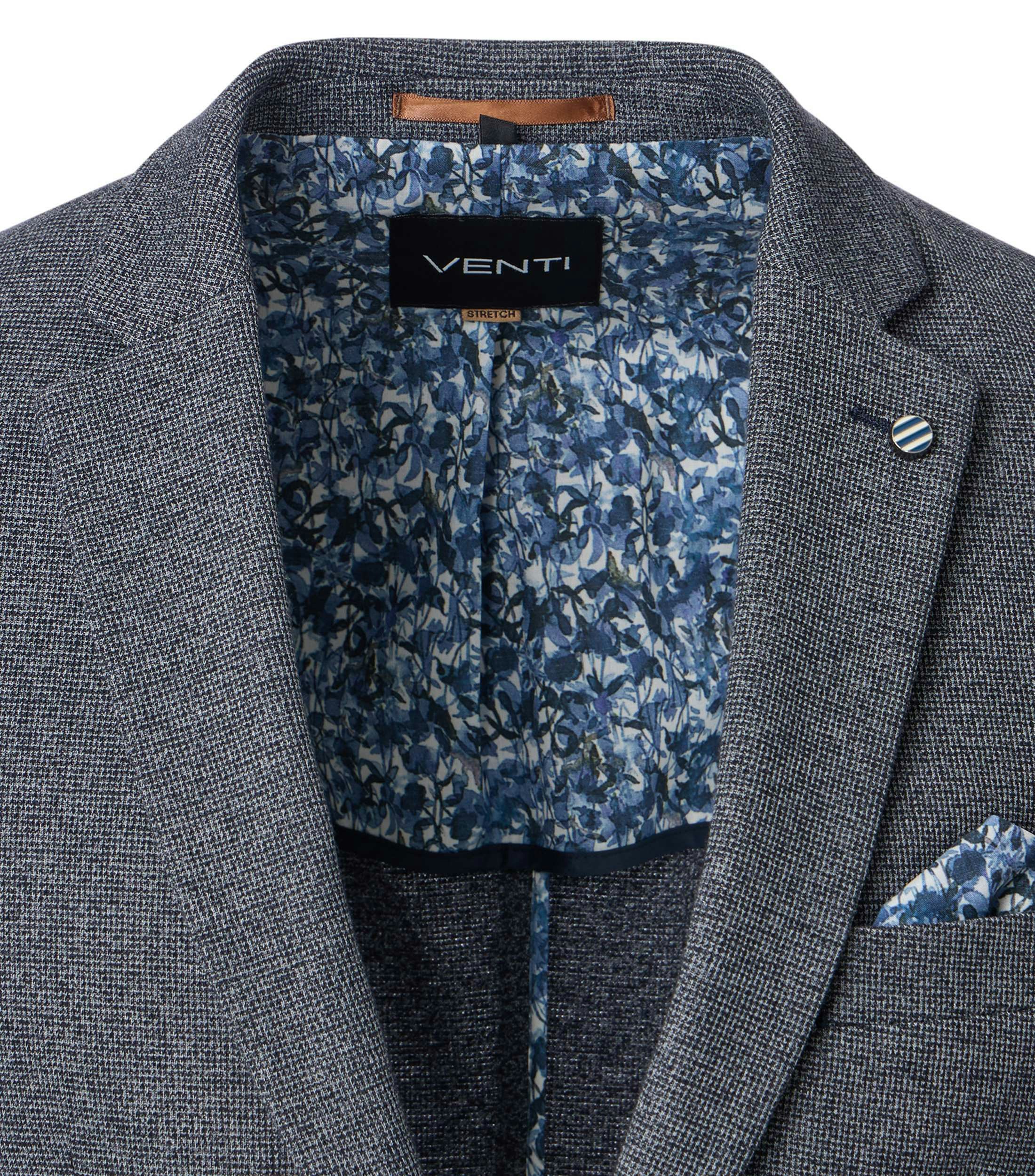 Das Model trägt ein Sakko im uni Muster in der Farbe Grau