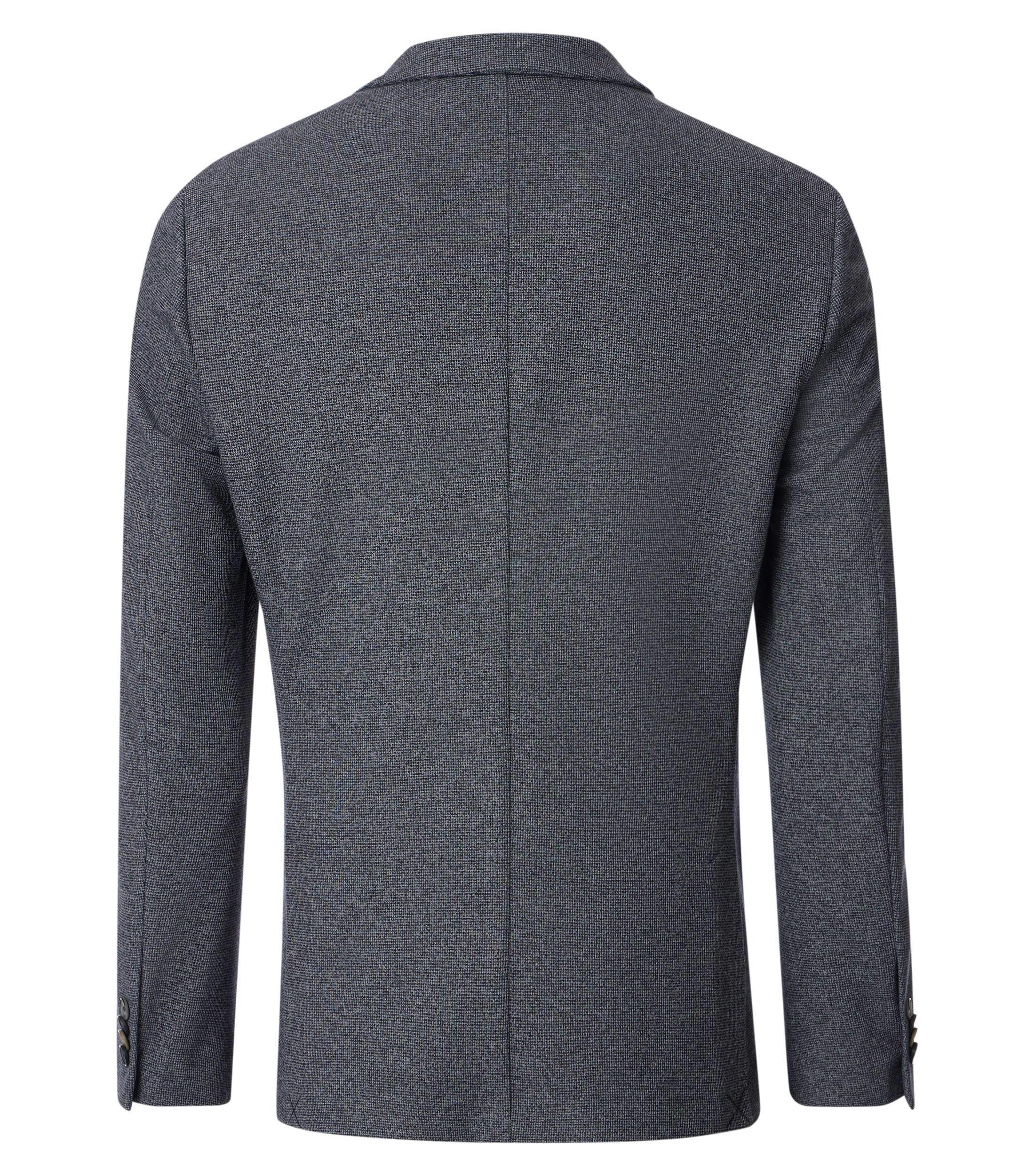 Das Model trägt ein Sakko im uni Muster in der Farbe Grau