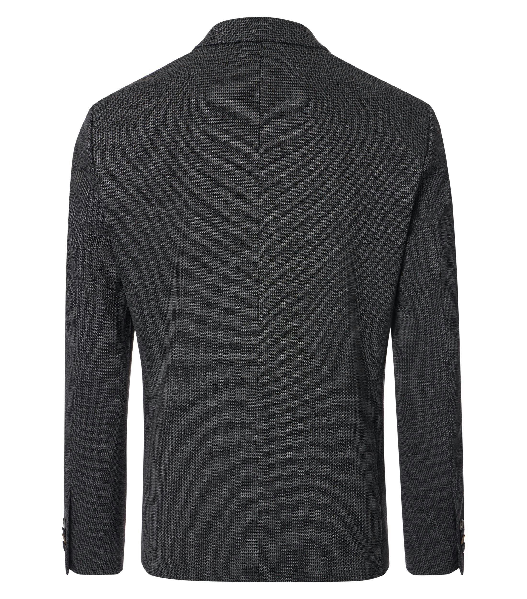 Das Model trägt ein Sakko im uni Muster in der Farbe Dunkelgrün