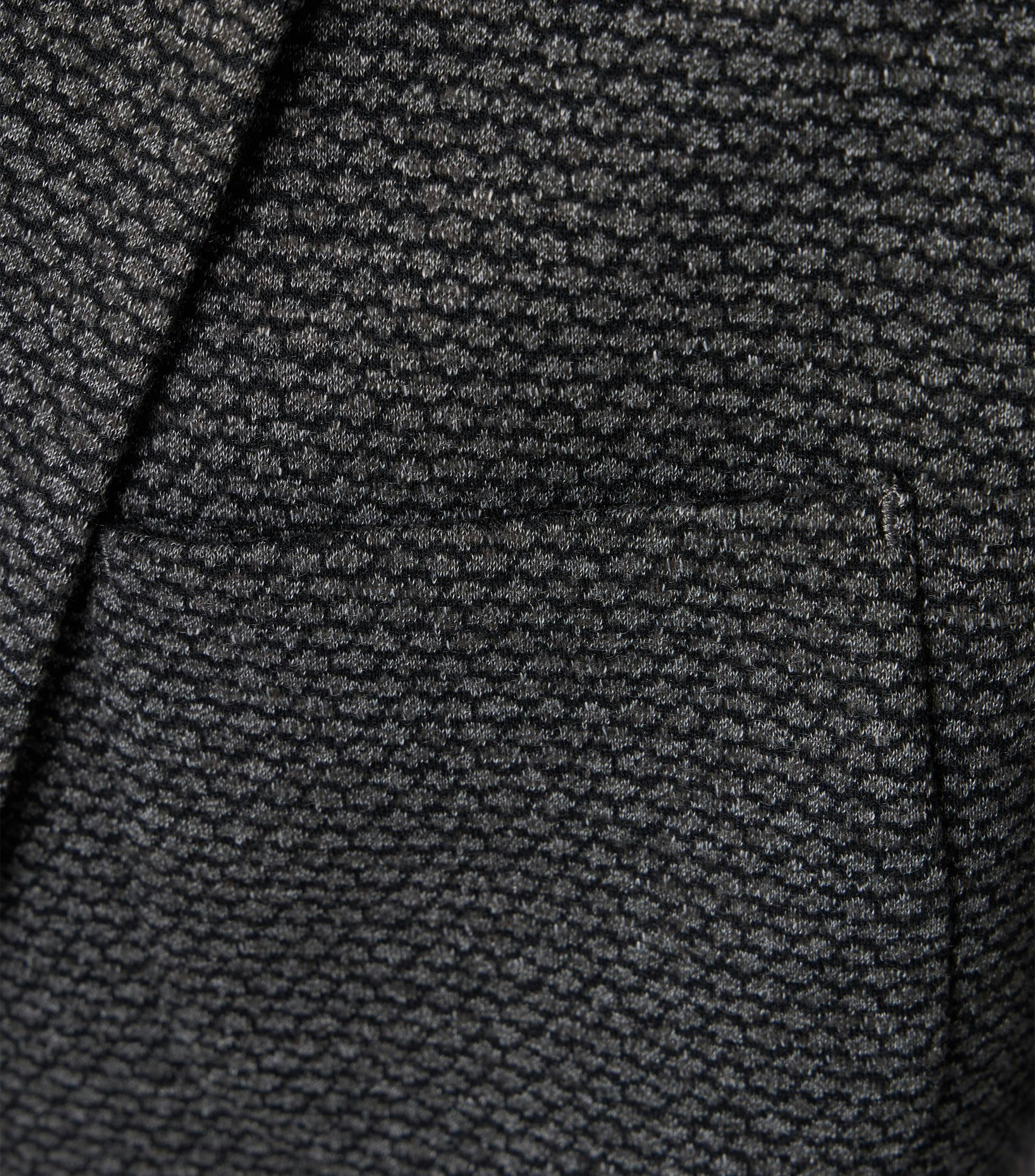 Das Model trägt ein Sakko im uni Muster in der Farbe Dunkelgrau