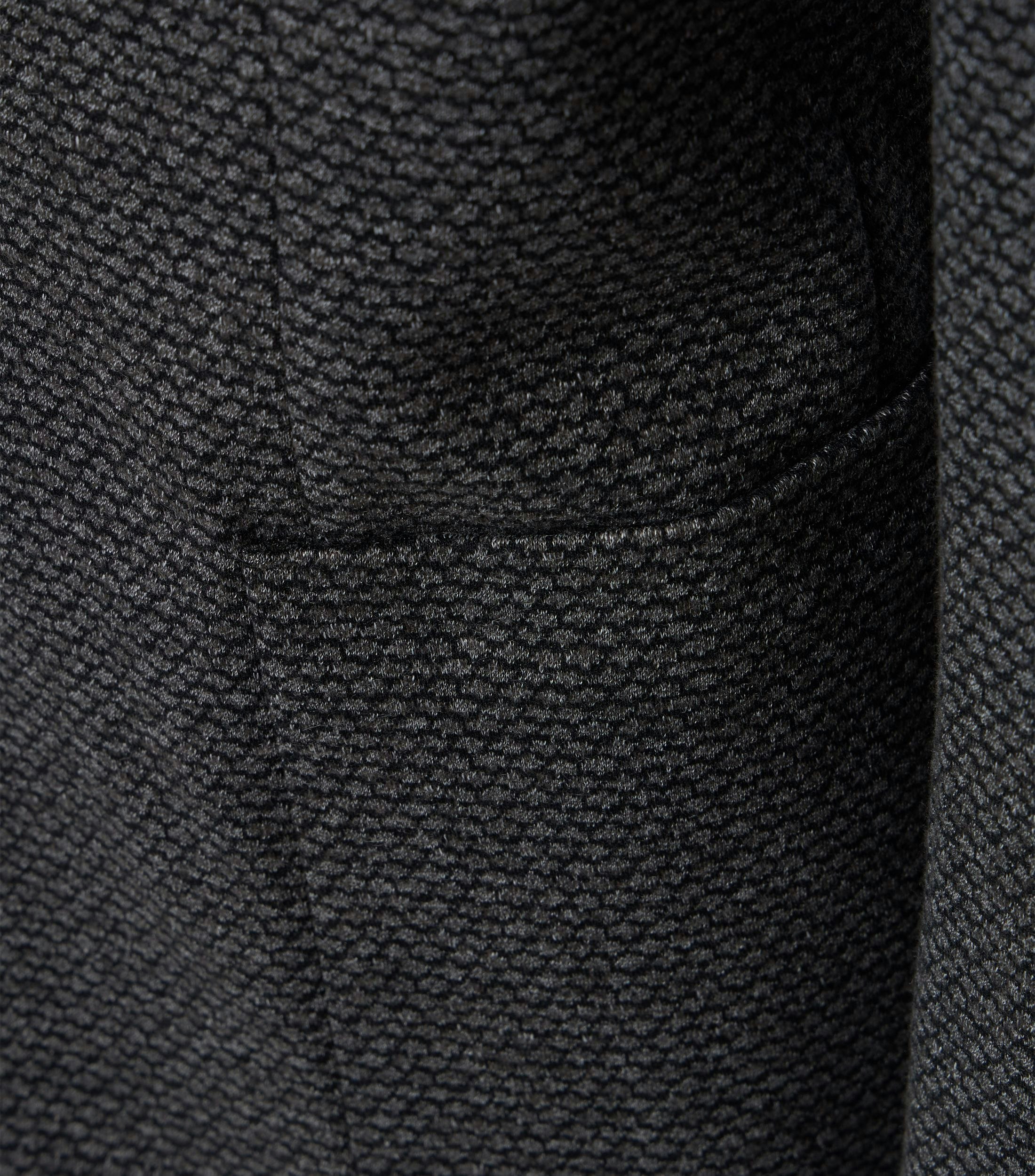 Das Model trägt ein Sakko im uni Muster in der Farbe Dunkelgrau