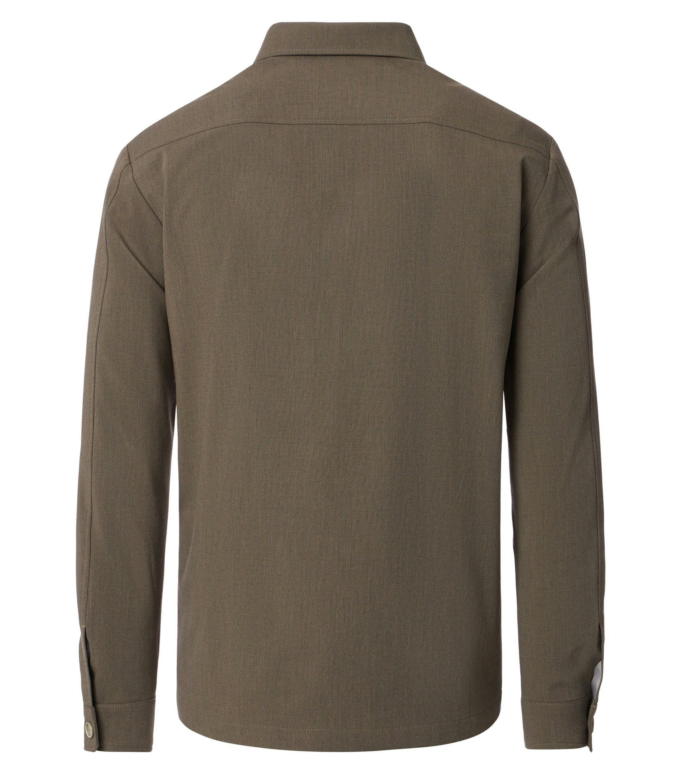 Das Model trägt ein Businesshemd im uni Muster in der Farbe Beige