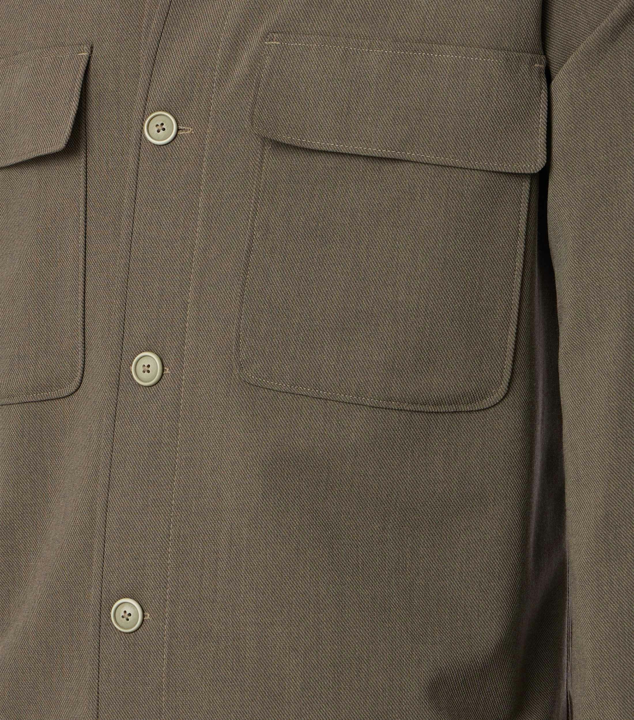 Das Model trägt ein Businesshemd im uni Muster in der Farbe Beige