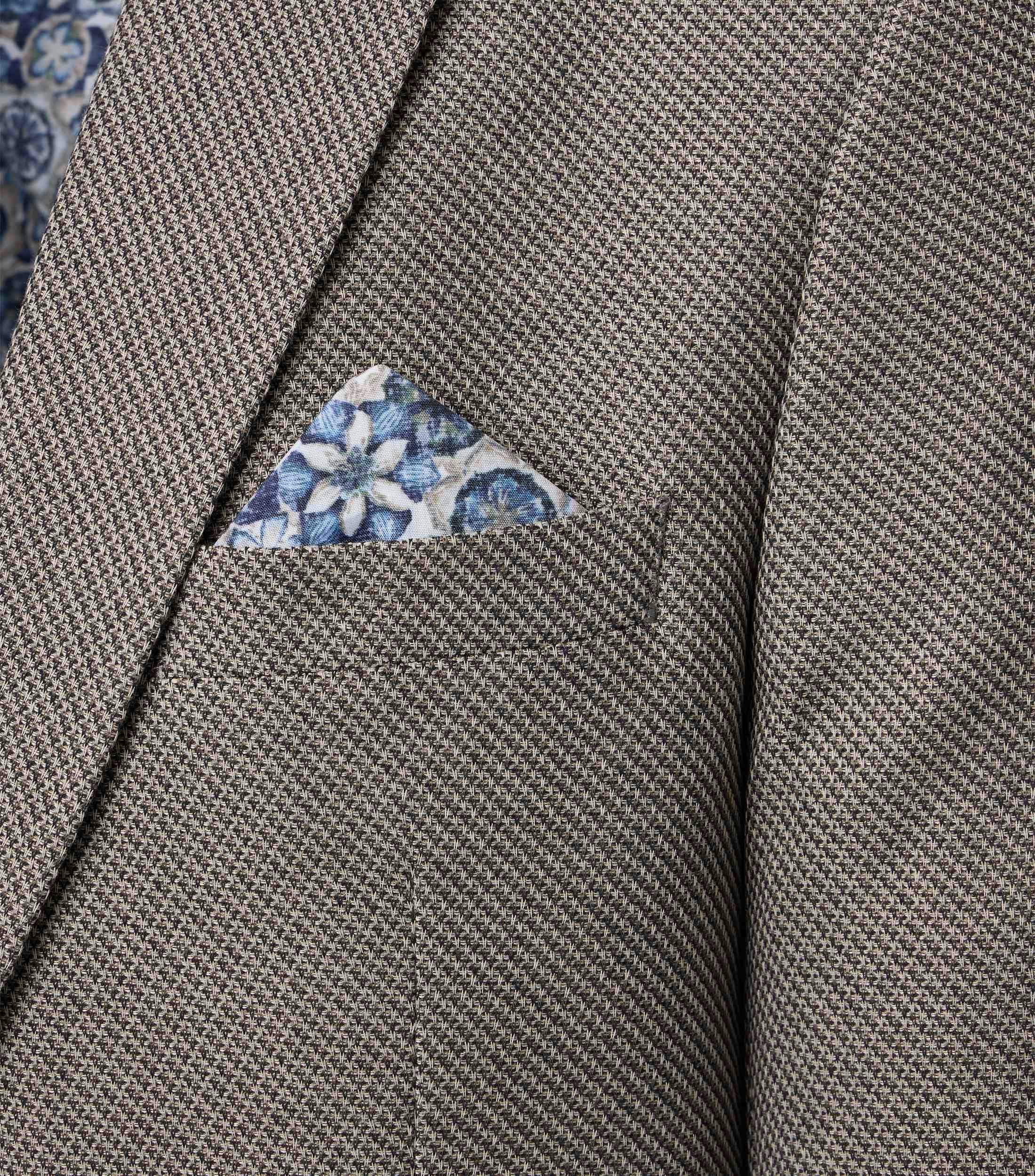 Das Model trägt ein Sakko im uni Muster in der Farbe Beige