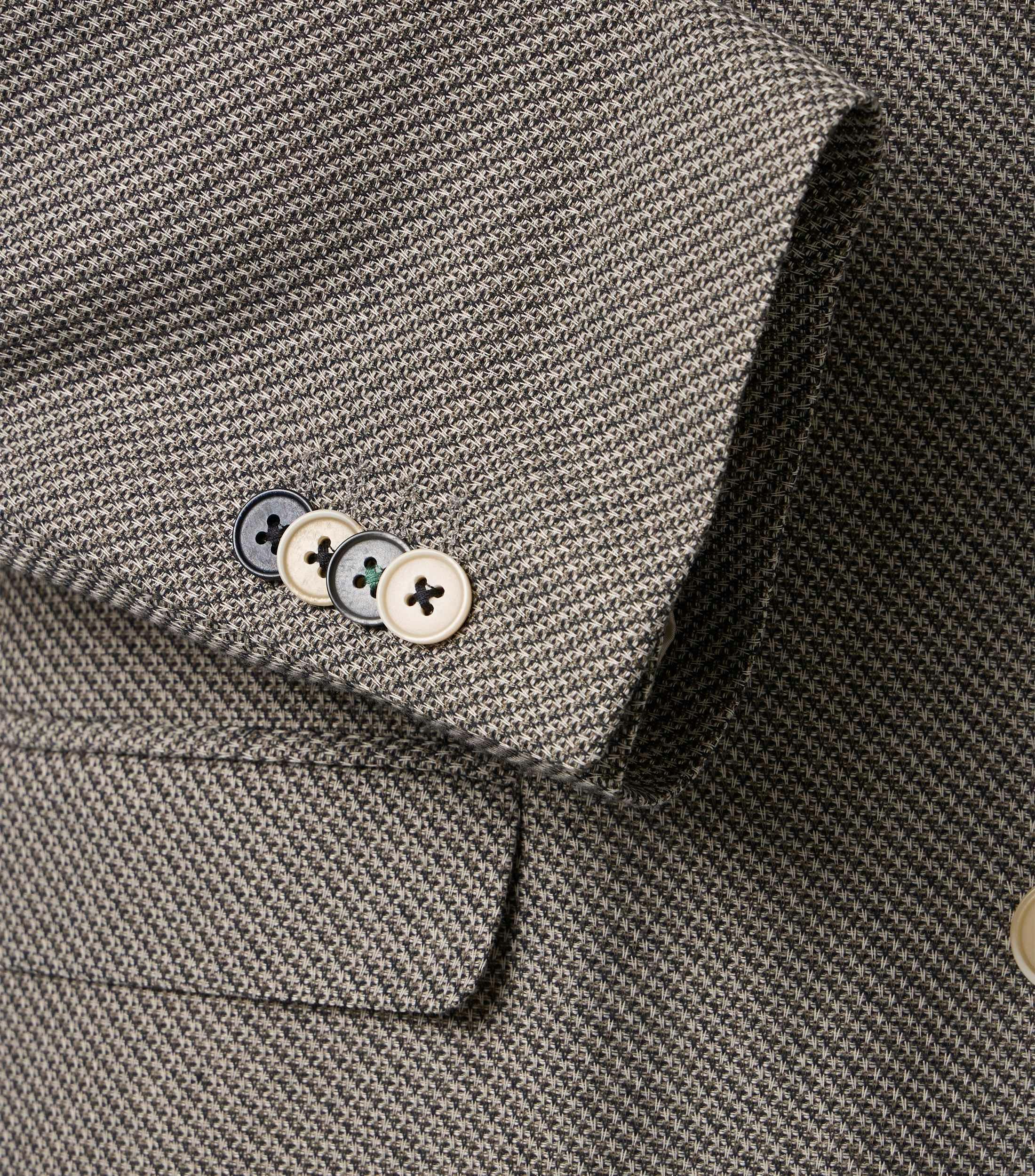 Das Model trägt ein Sakko im uni Muster in der Farbe Beige