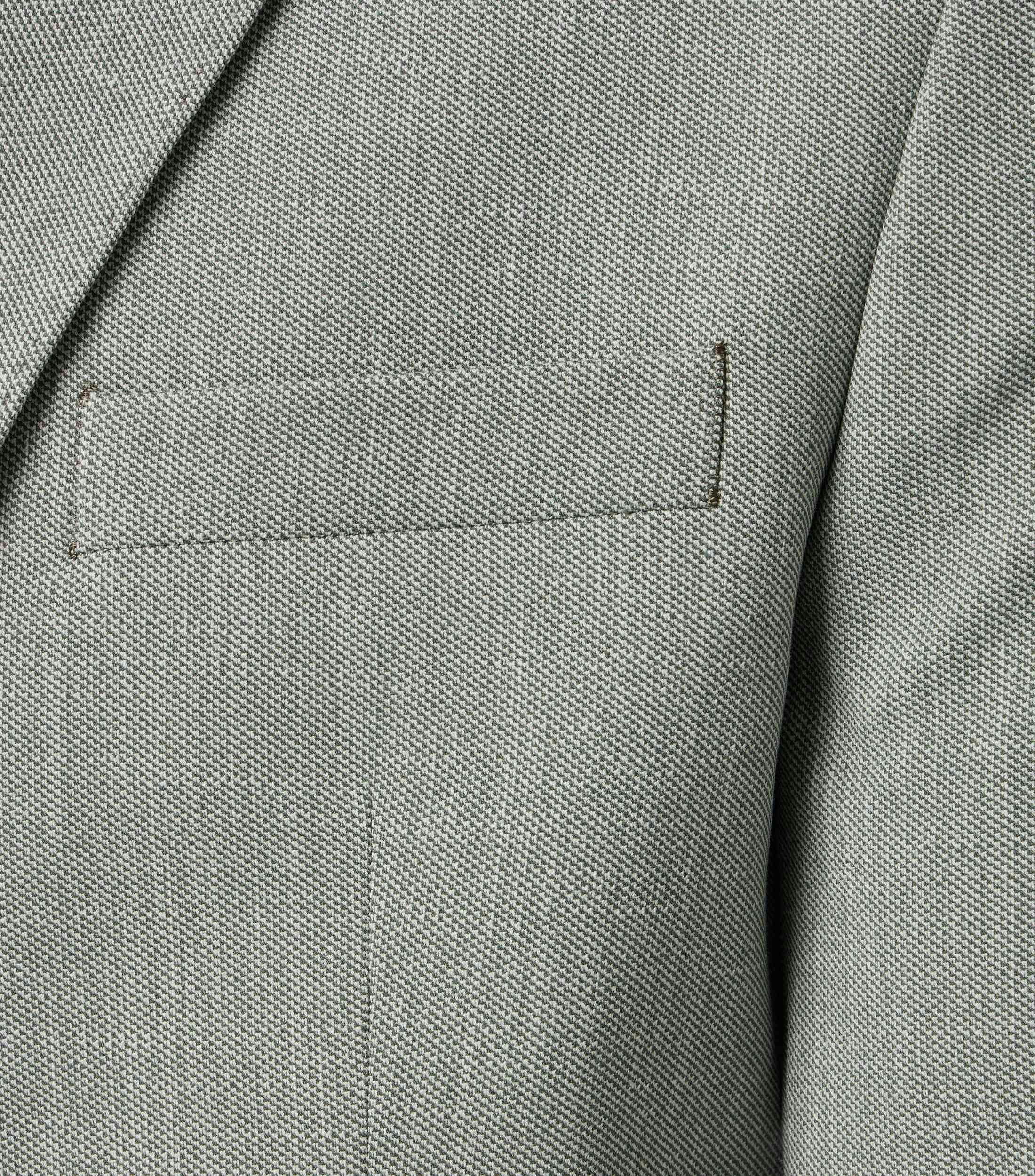 Das Model trägt ein Sakko im uni Muster in der Farbe Grün