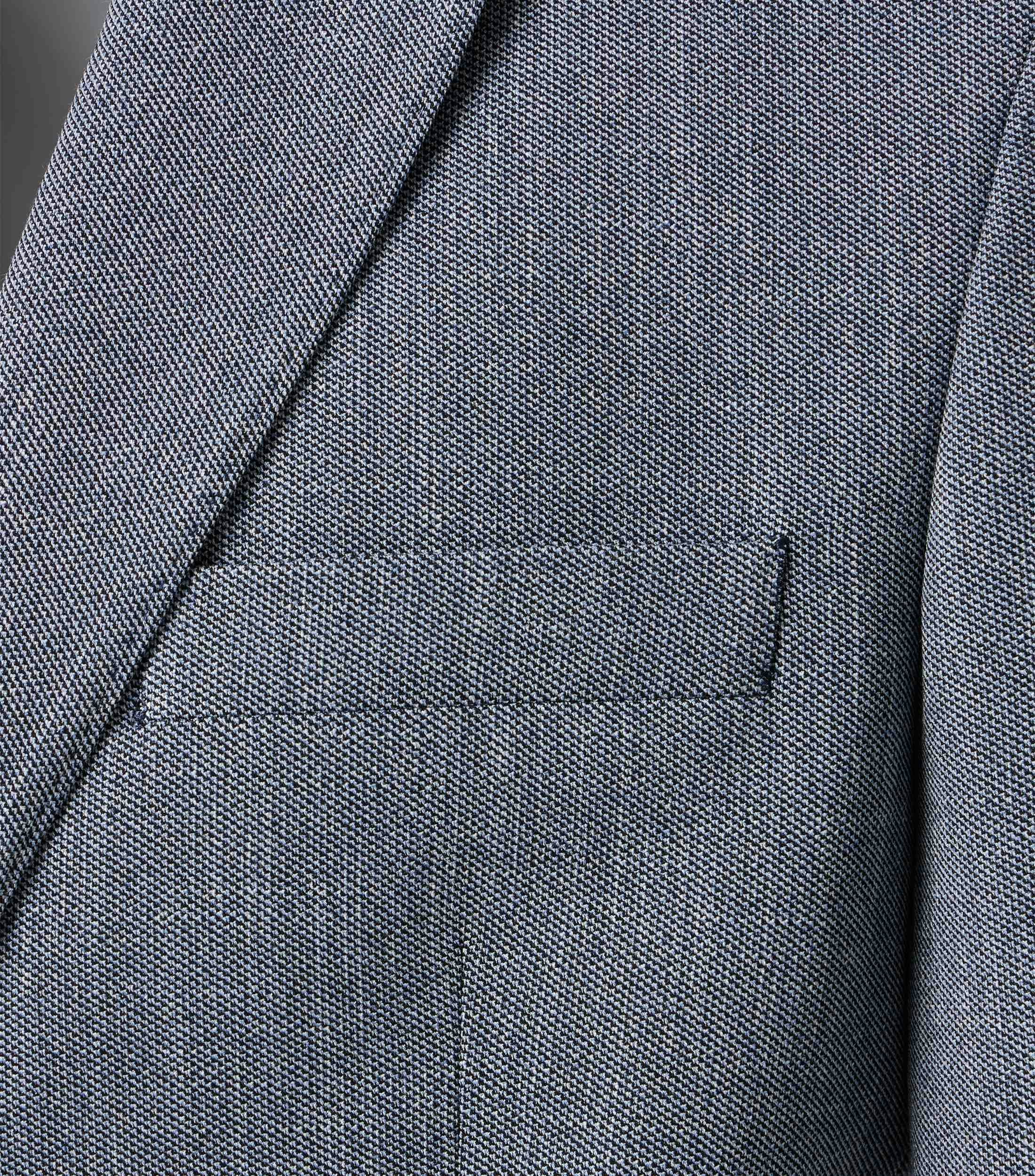 Das Model trägt ein Sakko im uni Muster in der Farbe Blau