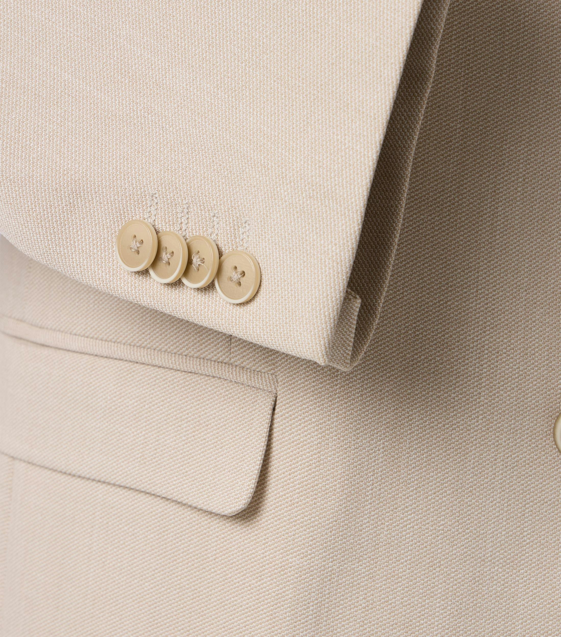 Das Model trägt ein Sakko im uni Muster in der Farbe Beige