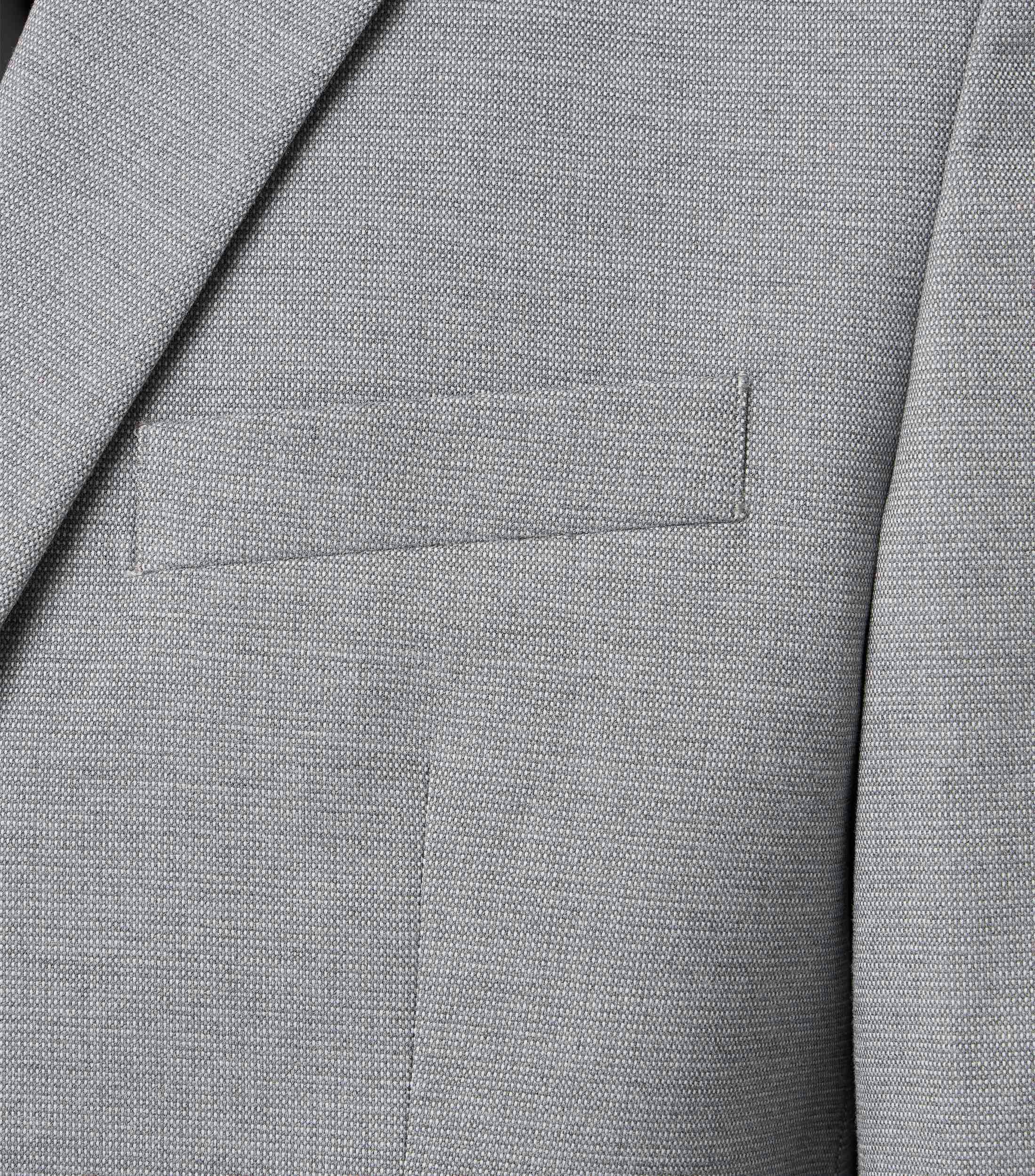 Das Model trägt ein Sakko im uni Muster in der Farbe Grau