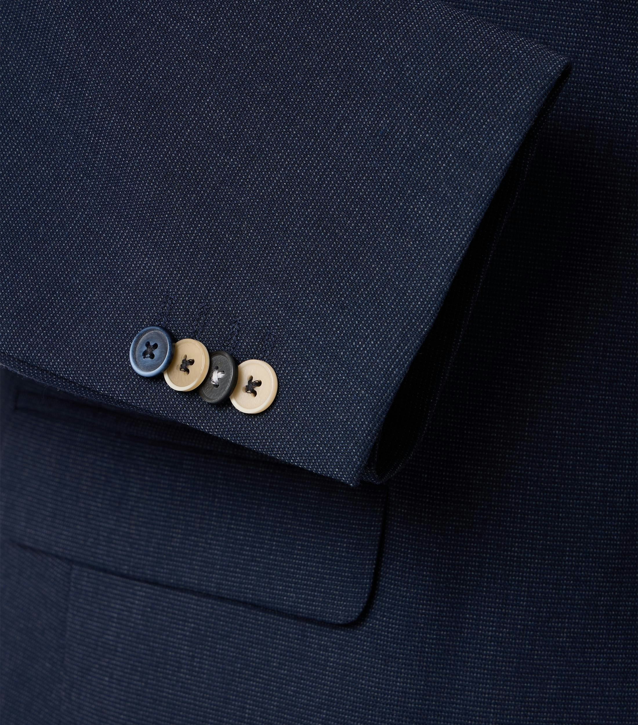 Das Model trägt ein Sakko im uni Muster in der Farbe Dunkelblau