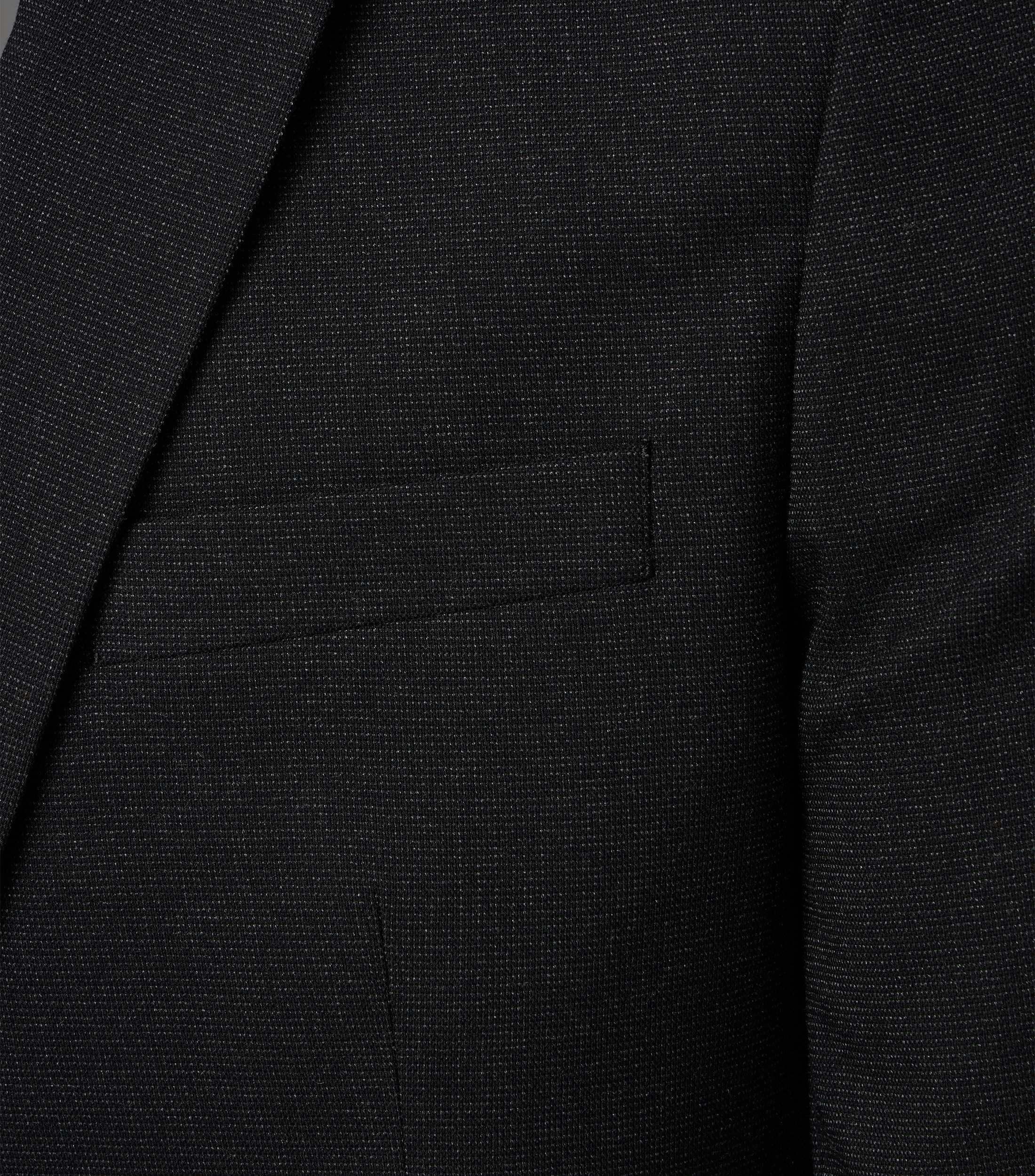 Das Model trägt ein Sakko im uni Muster in der Farbe Schwarz