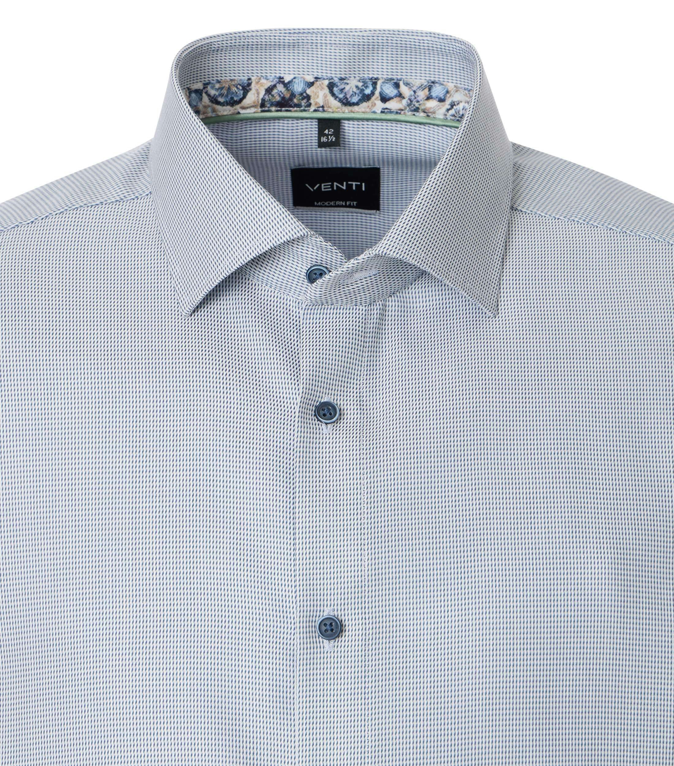 Das Model trägt ein Businesshemd im uni Muster in der Farbe helles Himmelblau