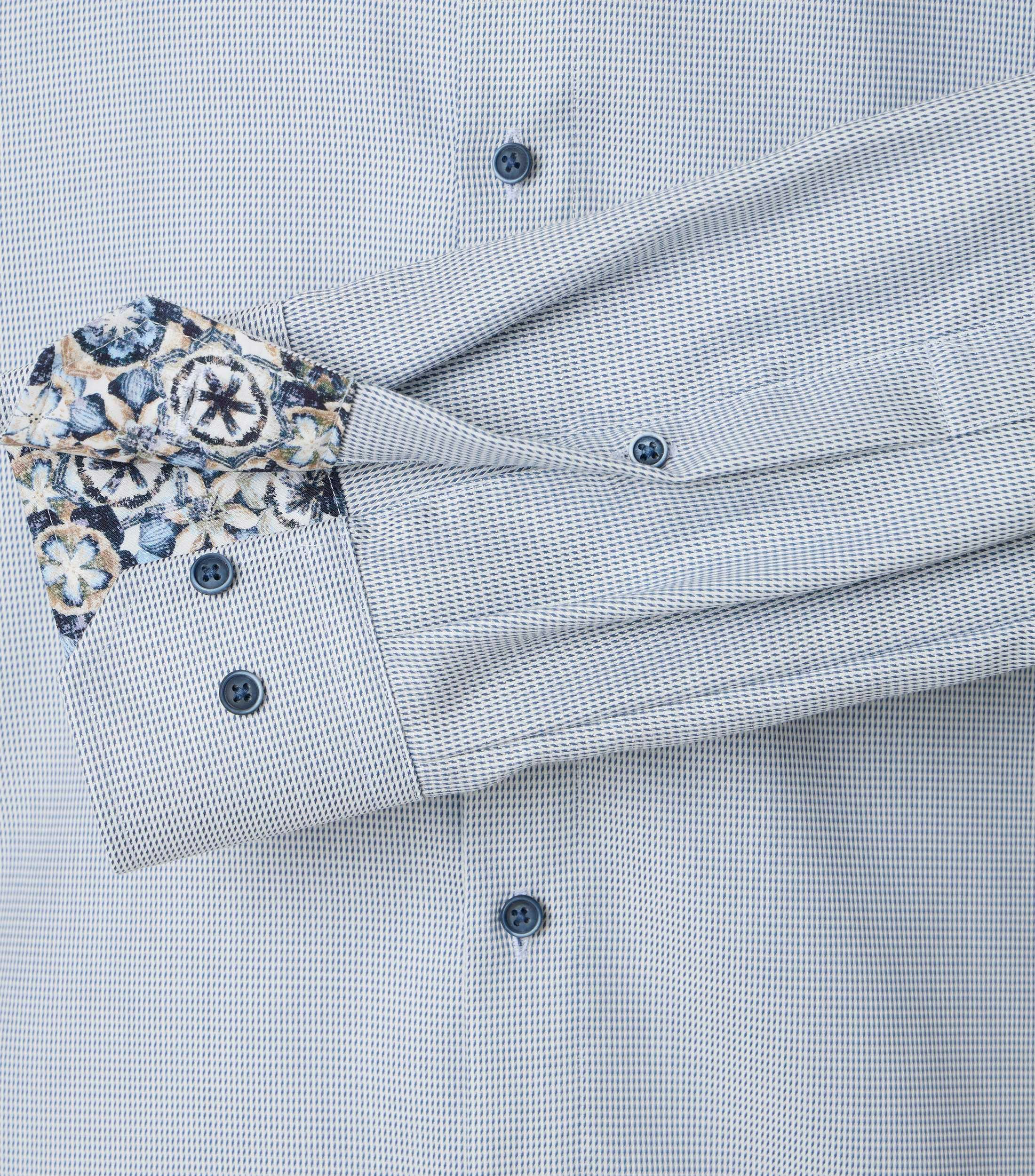 Das Model trägt ein Businesshemd im uni Muster in der Farbe helles Himmelblau