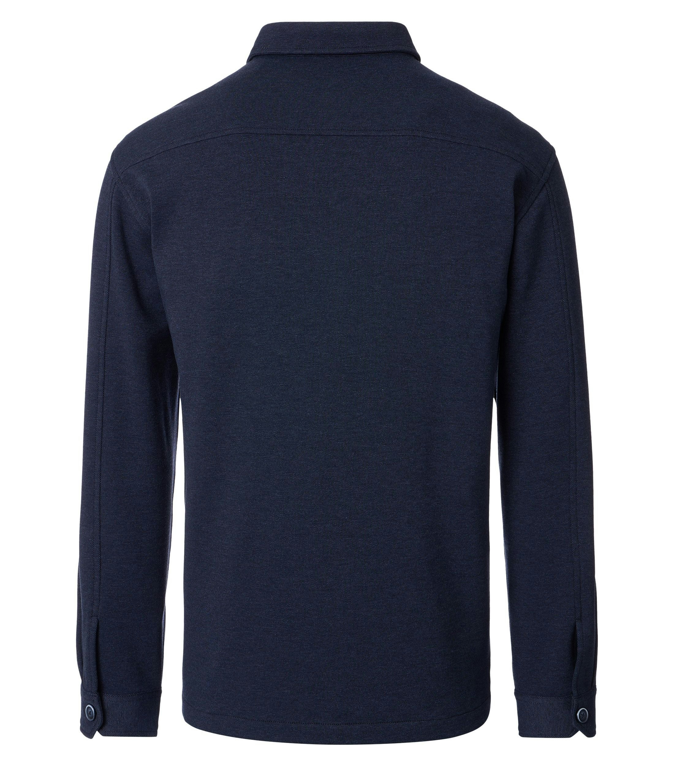 Das Model trägt ein Businesshemd im uni Muster in der Farbe Blau