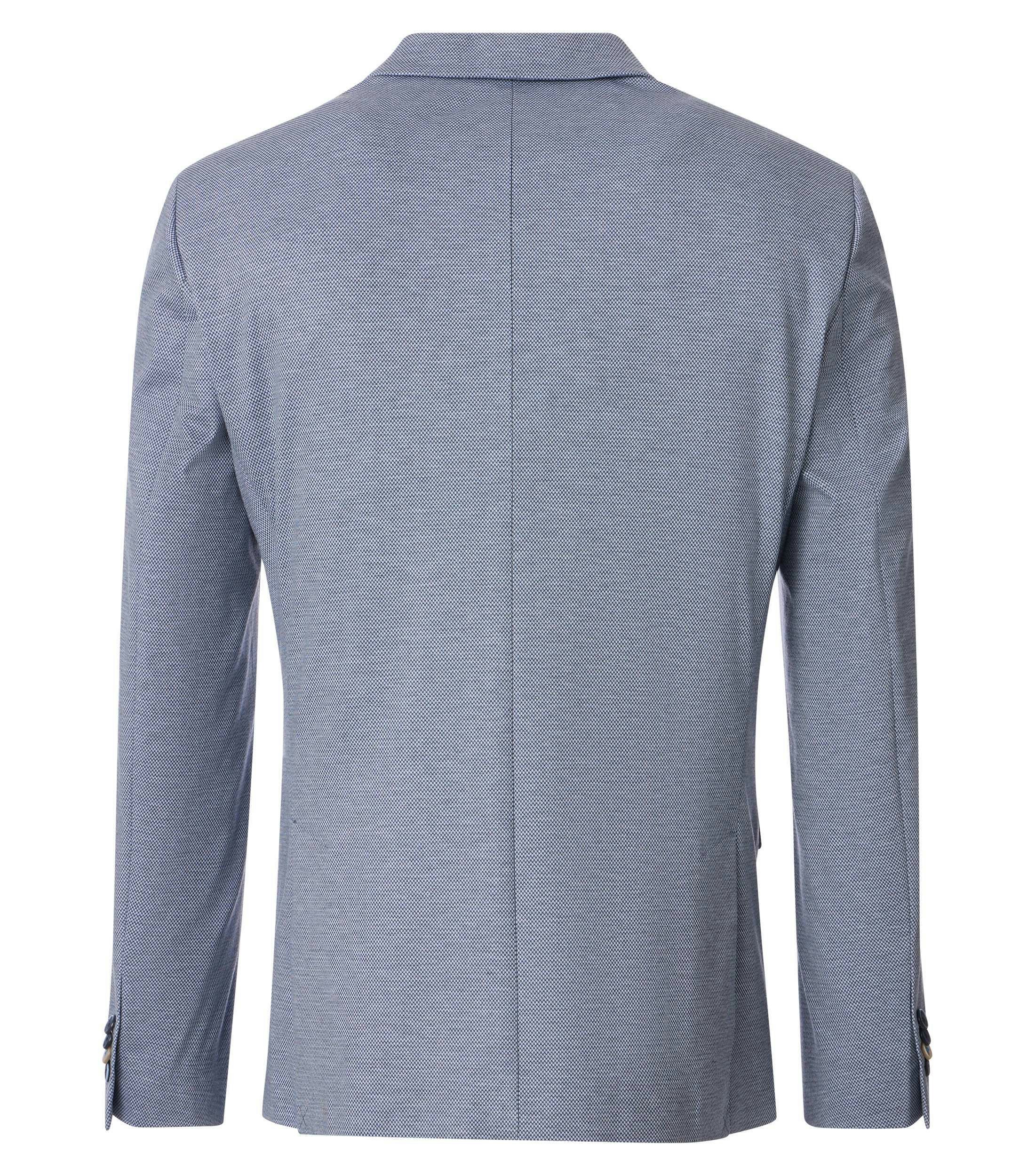 Das Model trägt ein Sakko im uni Muster in der Farbe Blau