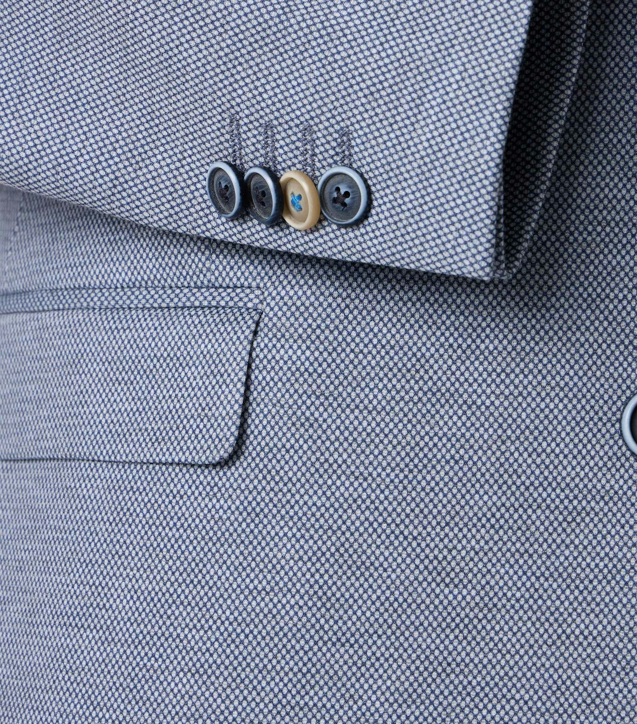 Das Model trägt ein Sakko im uni Muster in der Farbe Blau